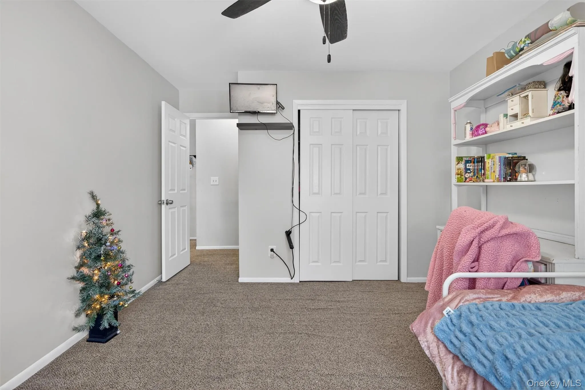Carpeted bedroom with a closet and ceiling fan Carpeted bedroom with a closet and ceiling fan
