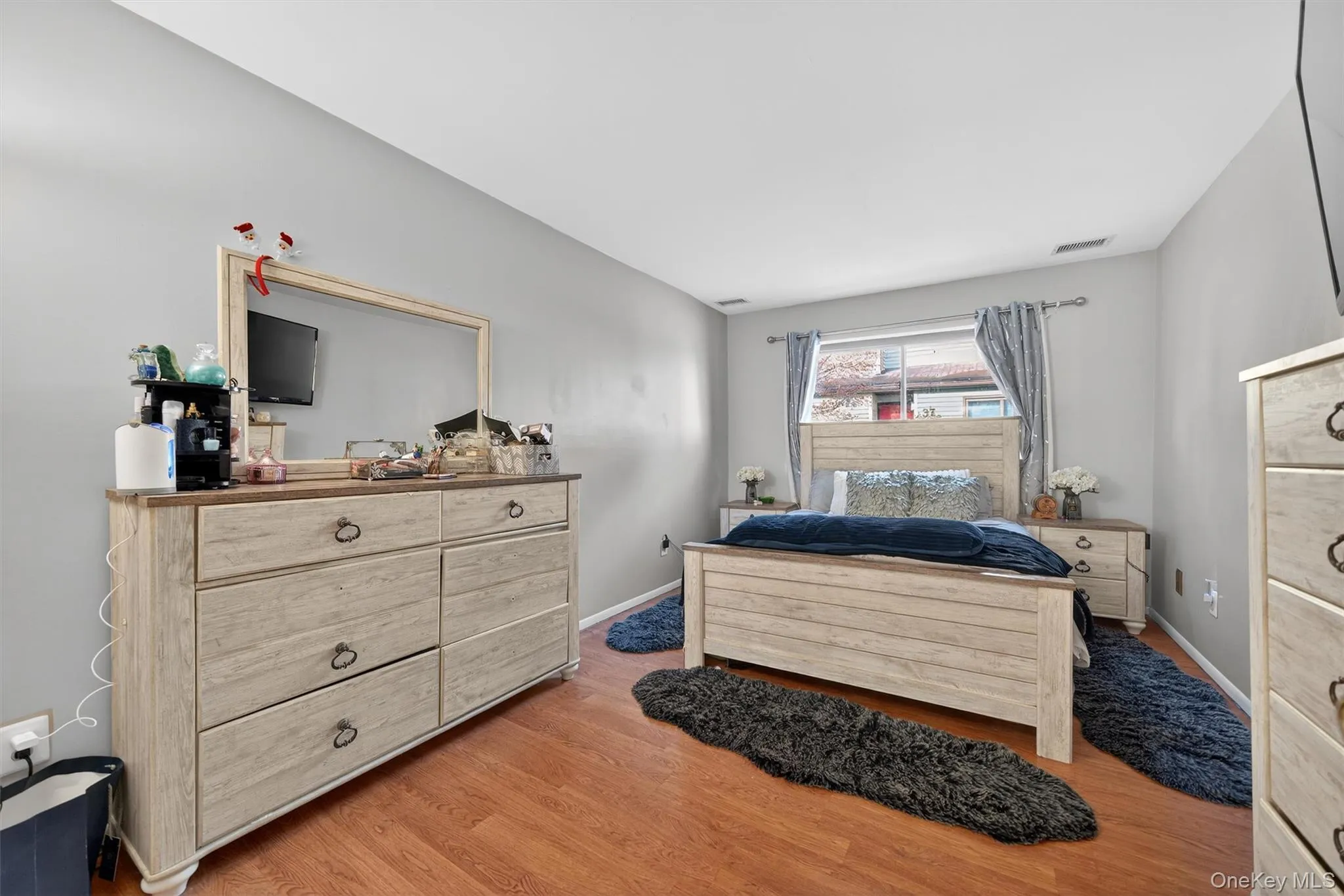 Bedroom with light wood finished floors and baseboards Bedroom with light wood finished floors and baseboards