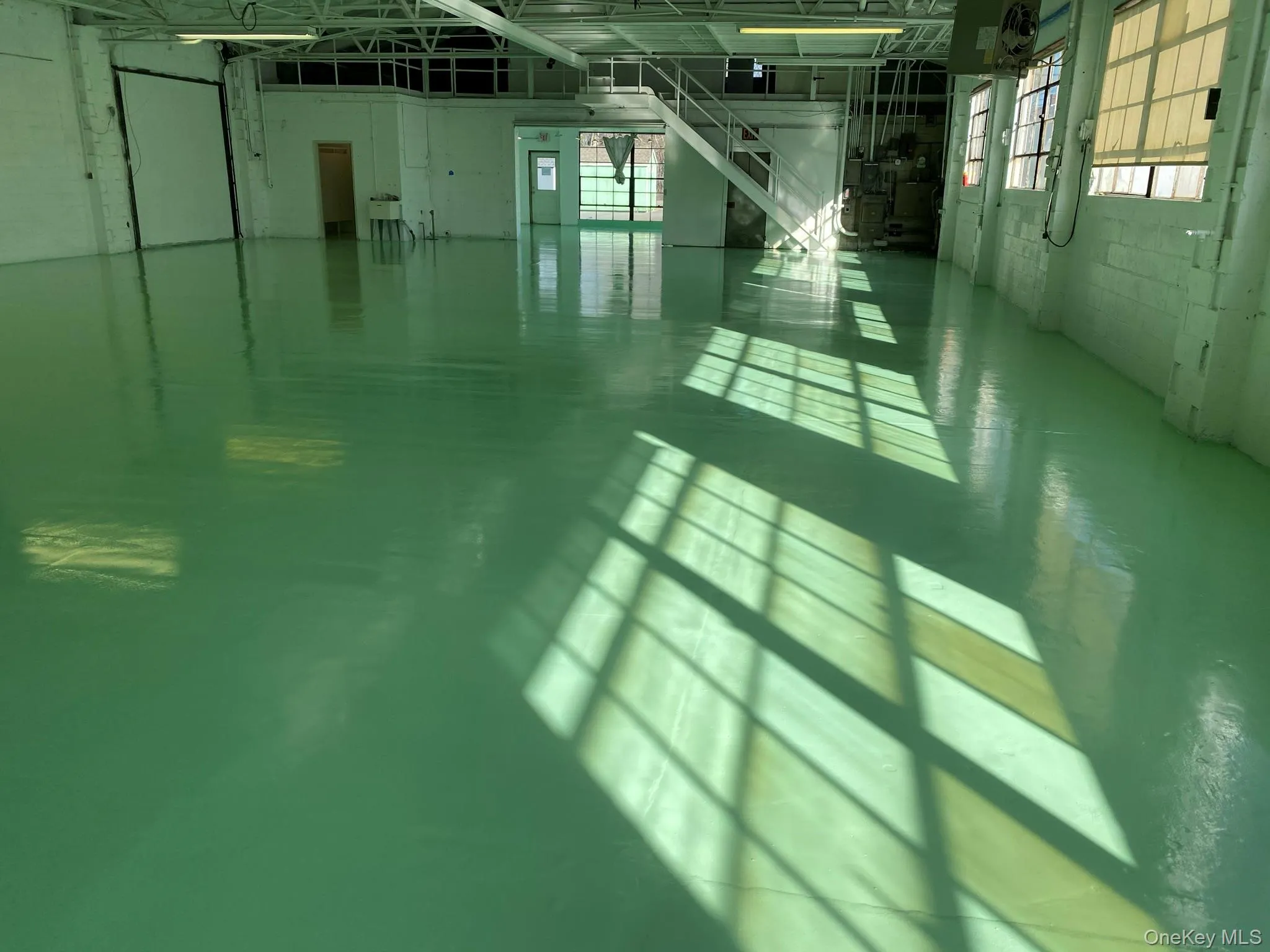 Clear-span industrial floor with perimeter windows and mezzanine access.Natural light, vertical utility, and functional warehouse configuration in one integrated space. Clear-span industrial floor with perimeter windows and mezzanine access.Natural light, vertical utility, and functional warehouse configuration in one integrated space.