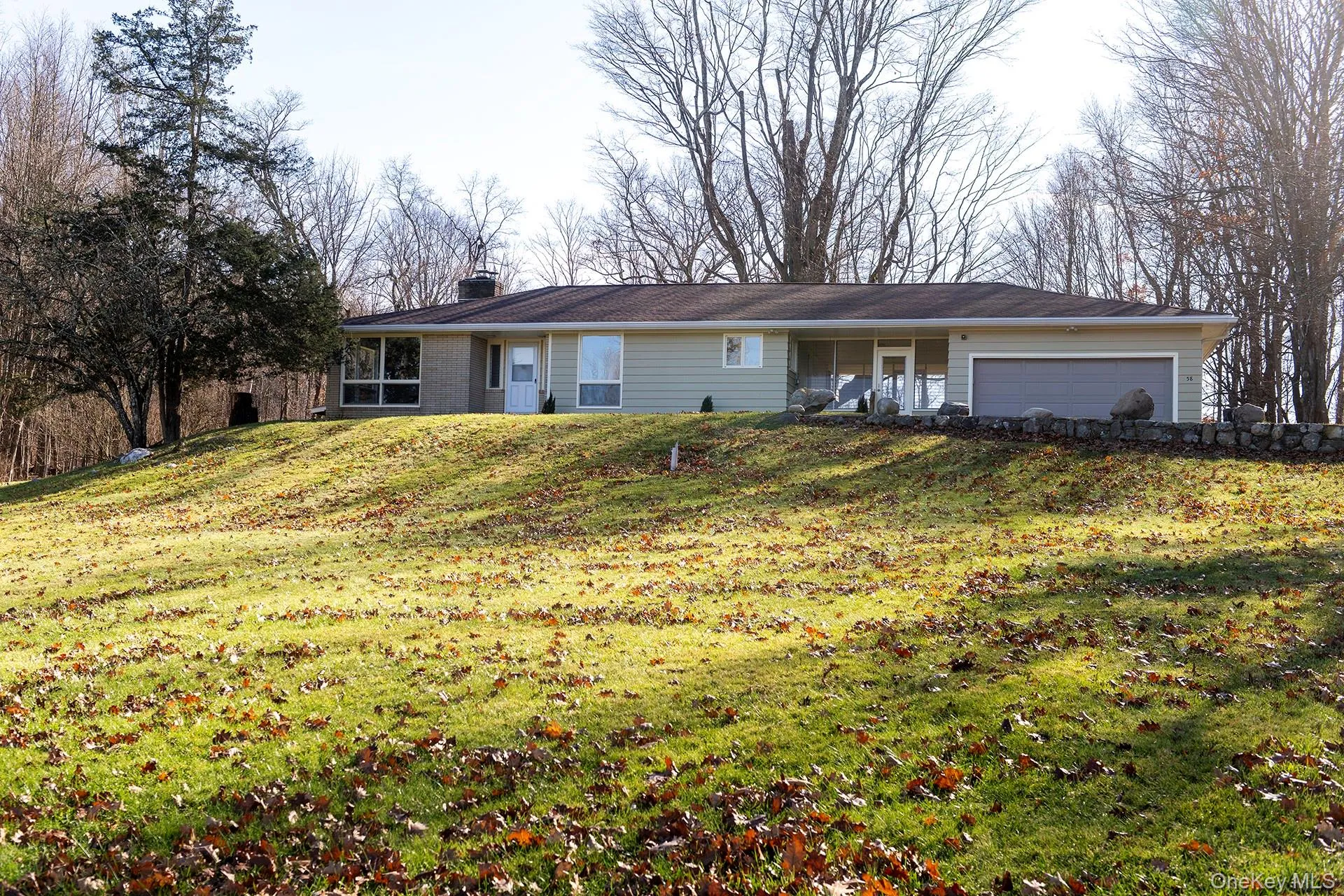 Ranch-style house with a front yard, a chimney, and a garage Ranch-style house with a front yard, a chimney, and a garage