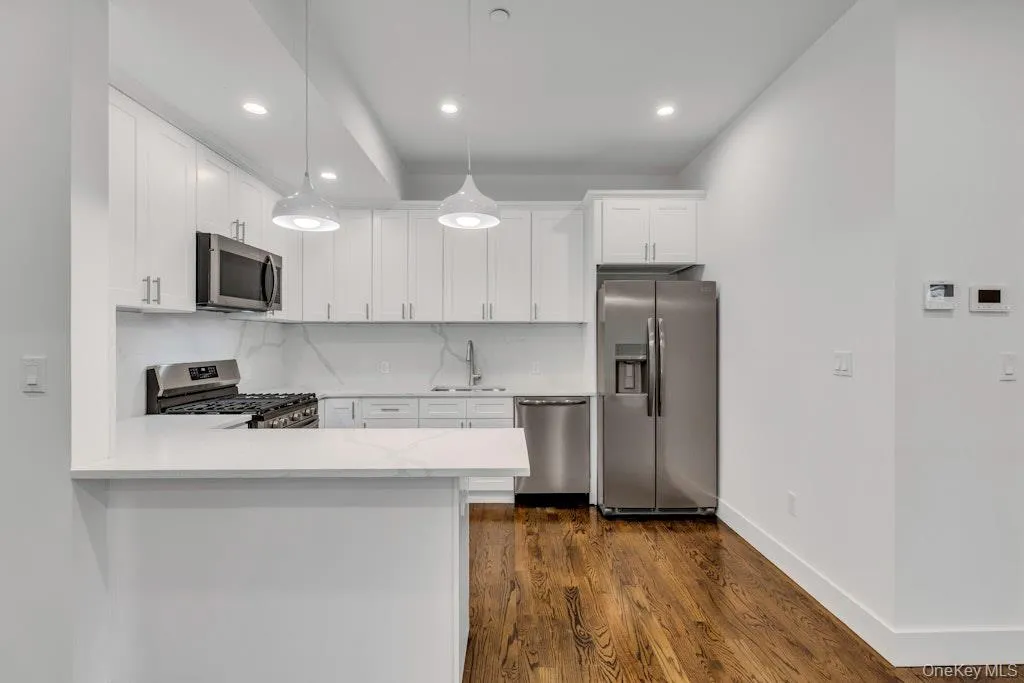 Kitchen featuring stainless steel appliances, white cabinetry Kitchen featuring stainless steel appliances, white cabinetry