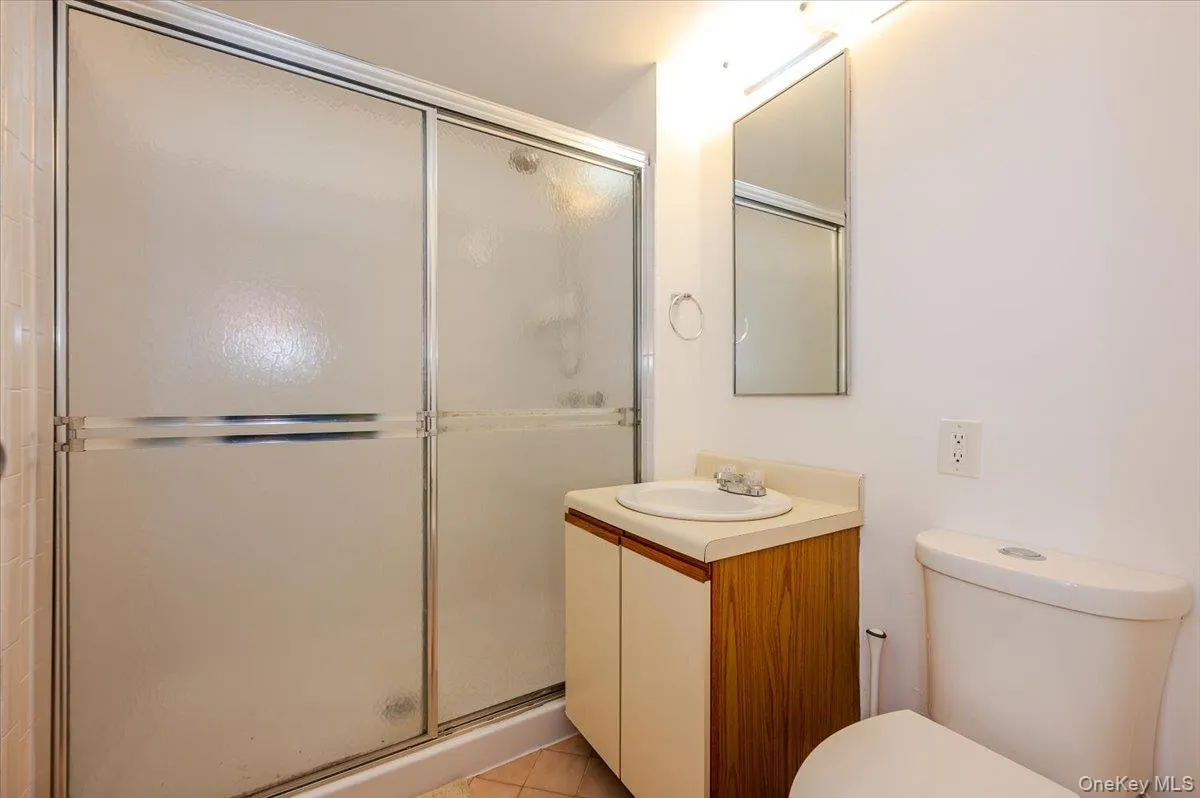 Bathroom with a shower stall, vanity, and light tile patterned flooring Bathroom with a shower stall, vanity, and light tile patterned flooring