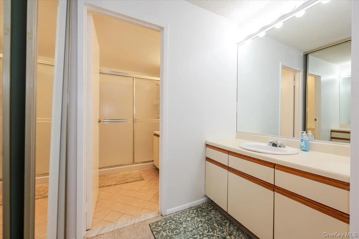 Full bathroom featuring vanity, a shower stall, and light tile patterned floors Full bathroom featuring vanity, a shower stall, and light tile patterned floors