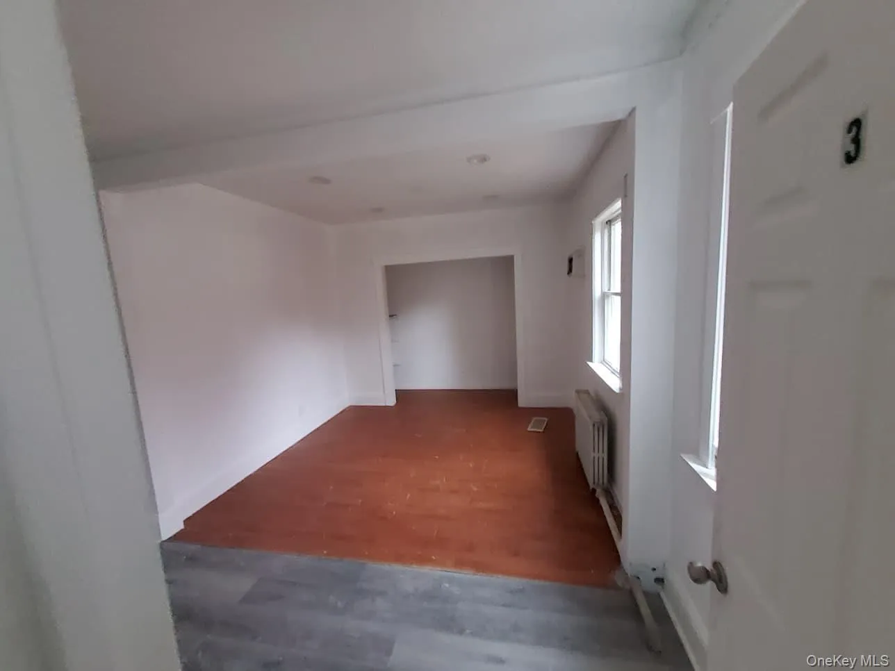 Hallway featuring wood finished floors and radiator Hallway featuring wood finished floors and radiator