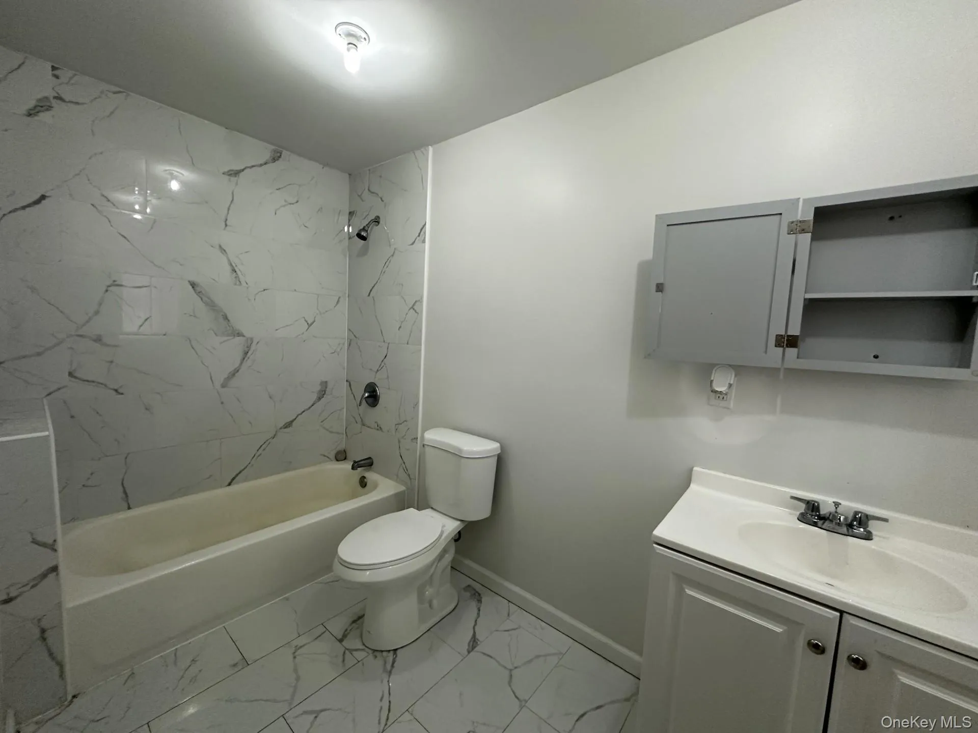 Bathroom with light marble finish floors, vanity, and shower / bathtub combination Bathroom with light marble finish floors, vanity, and shower / bathtub combination