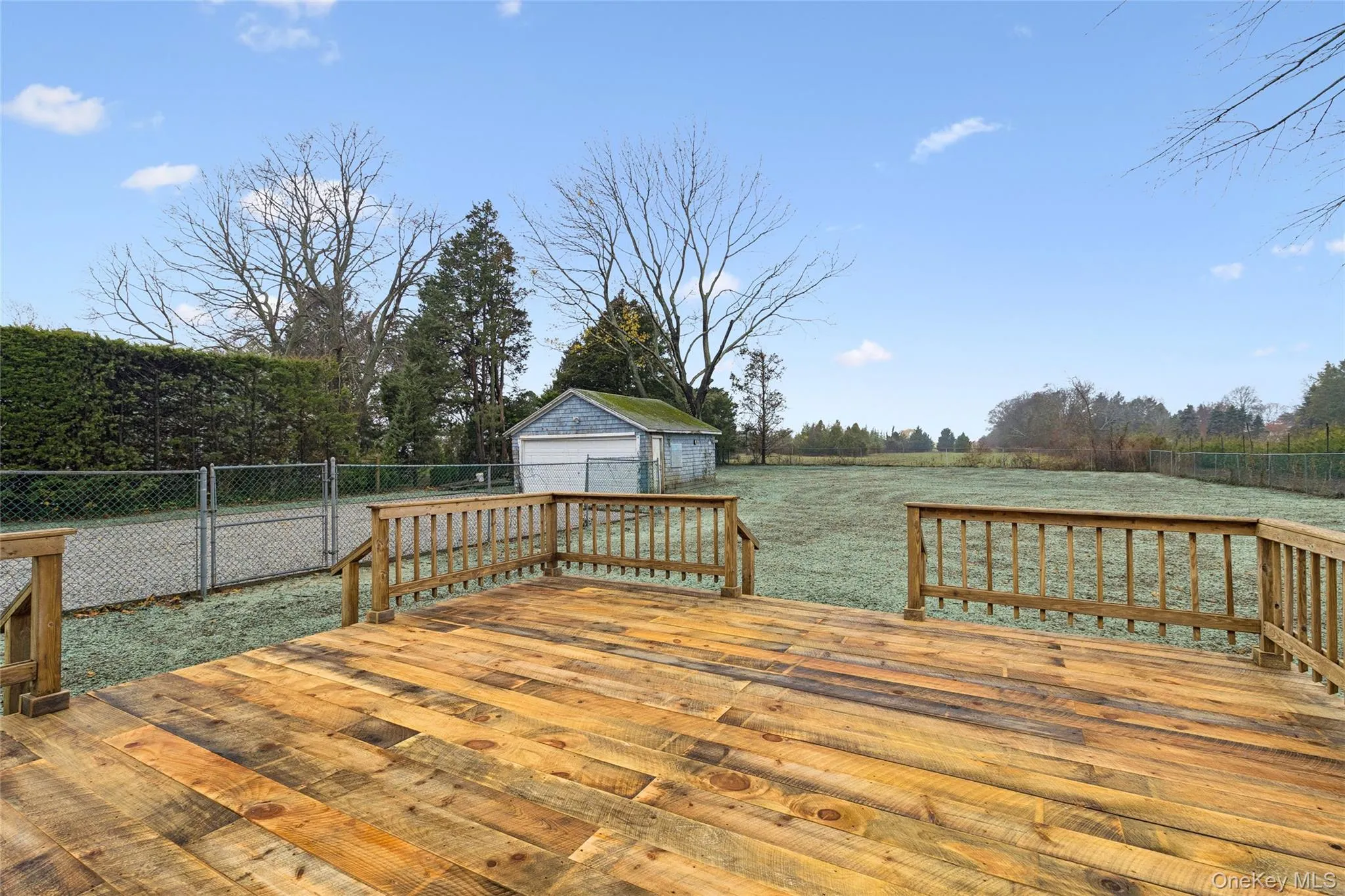 Wooden deck with a detached garage and an outbuilding Wooden deck with a detached garage and an outbuilding