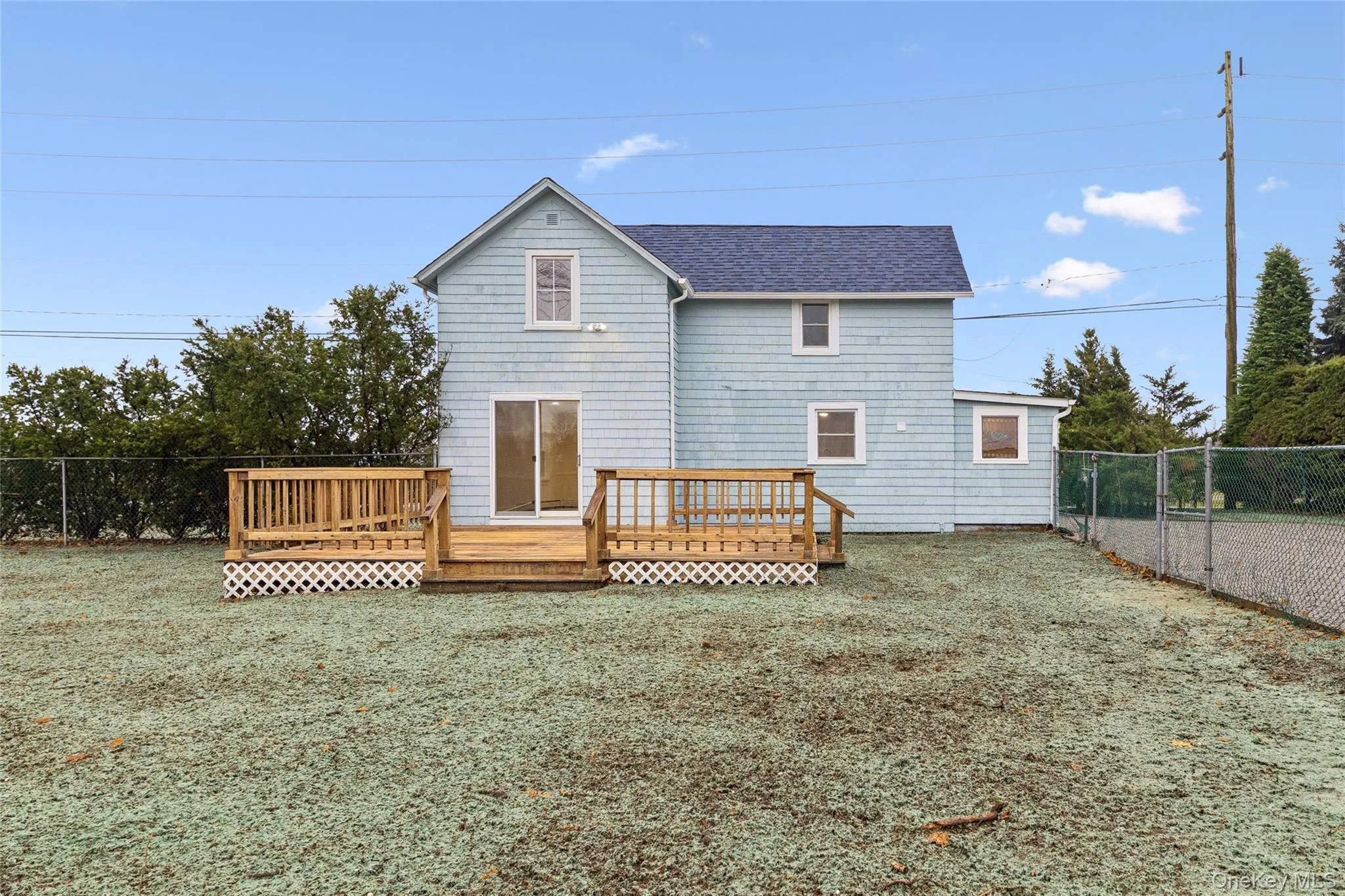 Back of property featuring a fenced backyard, a shingled roof, and a wooden deck Back of property featuring a fenced backyard, a shingled roof, and a wooden deck