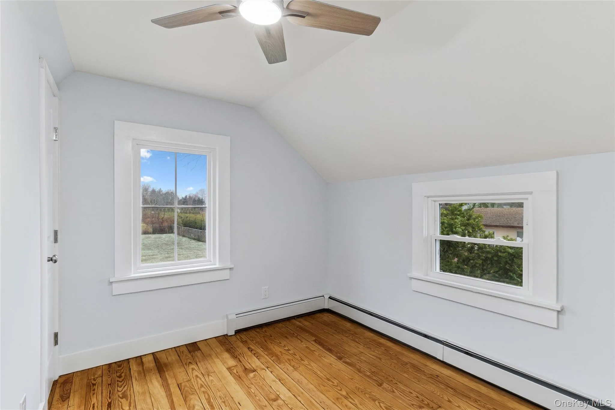 Additional living space with lofted ceiling, a baseboard radiator, light wood-style floors, and ceiling fan Additional living space with lofted ceiling, a baseboard radiator, light wood-style floors, and ceiling fan