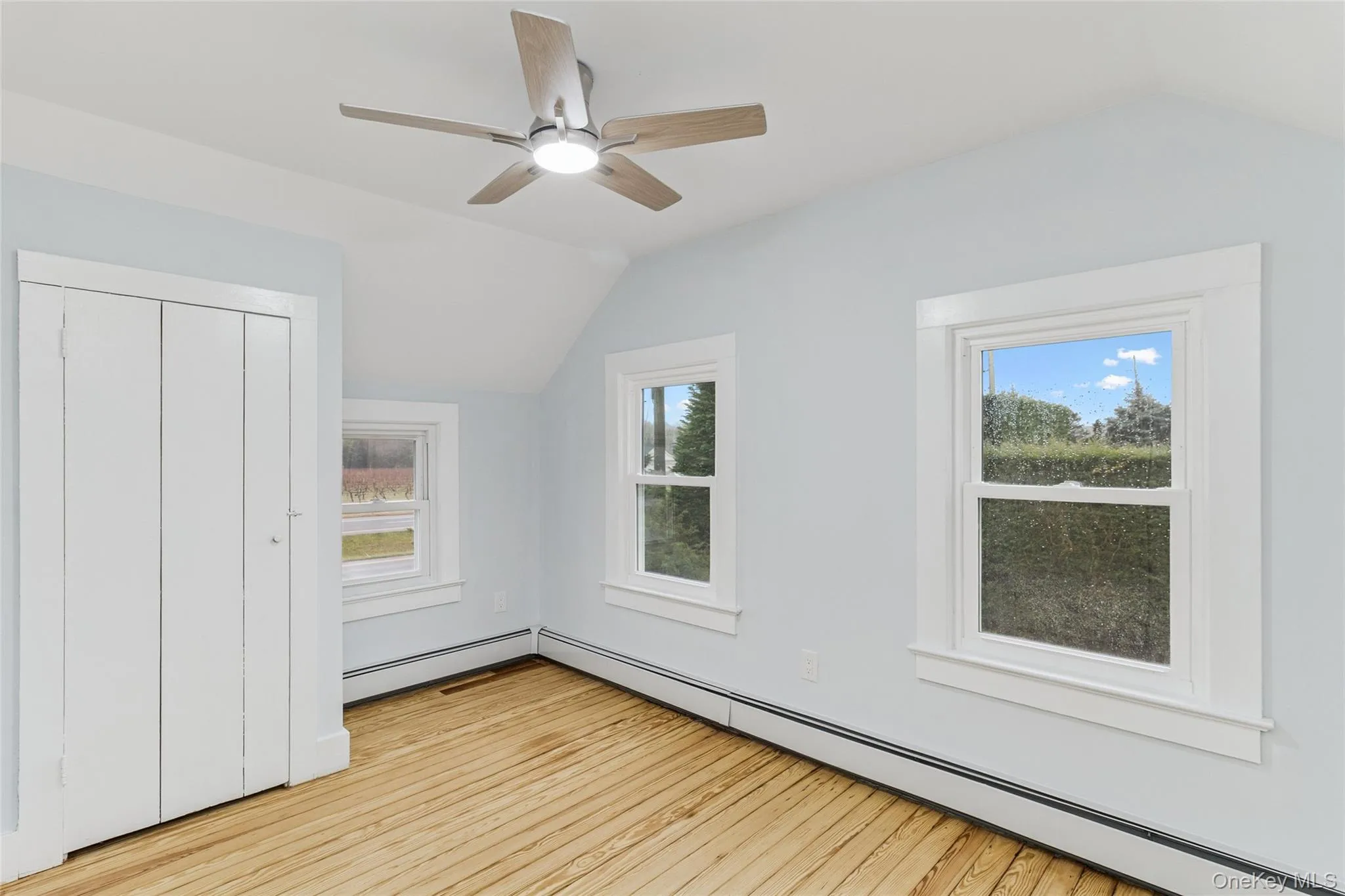 Bonus room featuring lofted ceiling, a baseboard heating unit, healthy amount of natural light, light wood-type flooring, and a ceiling fan Bonus room featuring lofted ceiling, a baseboard heating unit, healthy amount of natural light, light wood-type flooring, and a ceiling fan