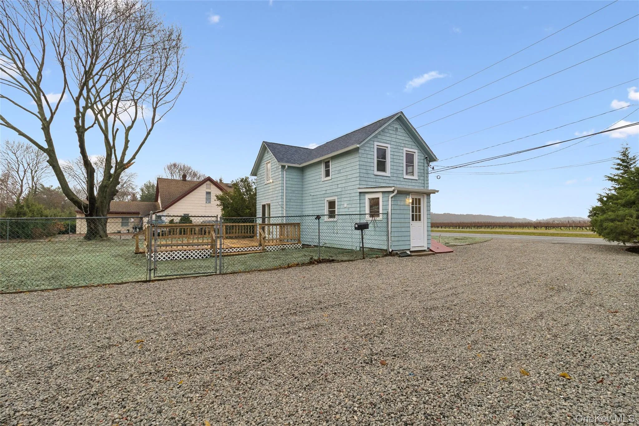 View of side of property featuring a wooden deck and a gate View of side of property featuring a wooden deck and a gate