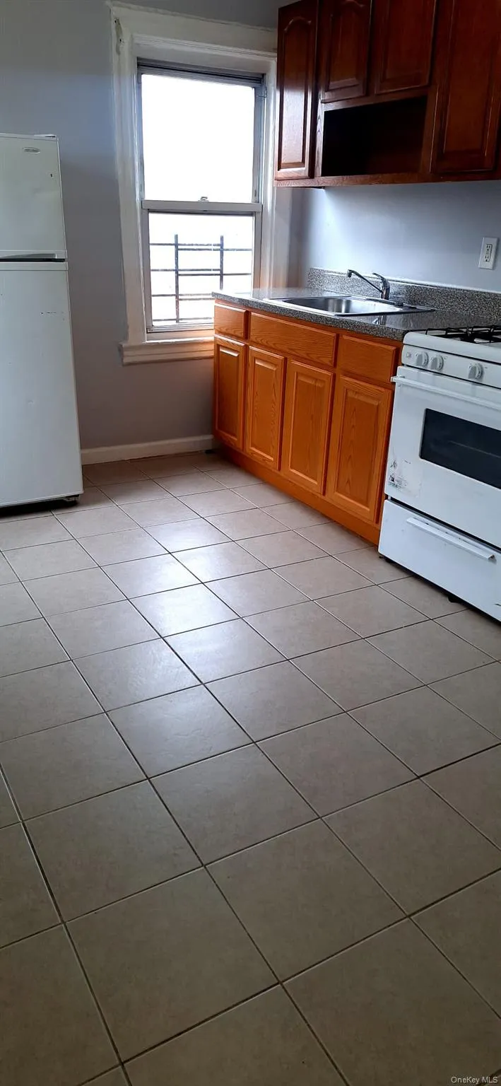 Kitchen with white appliances and light tile patterned flooring Kitchen with white appliances and light tile patterned flooring