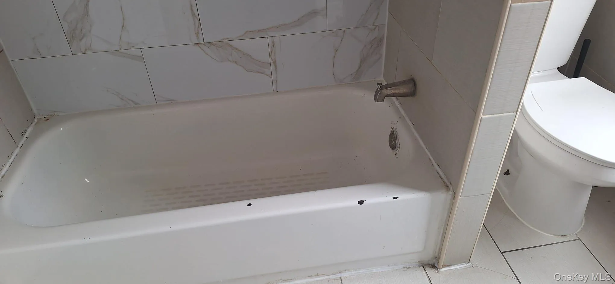 Full bathroom with a tub to relax in and tile patterned flooring Full bathroom with a tub to relax in and tile patterned flooring