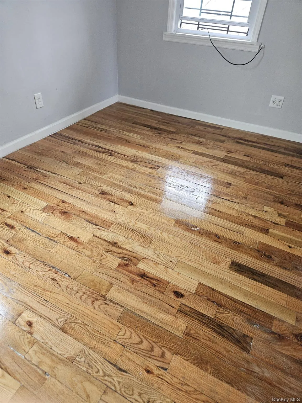 Empty room with light wood-style flooring and baseboards Empty room with light wood-style flooring and baseboards