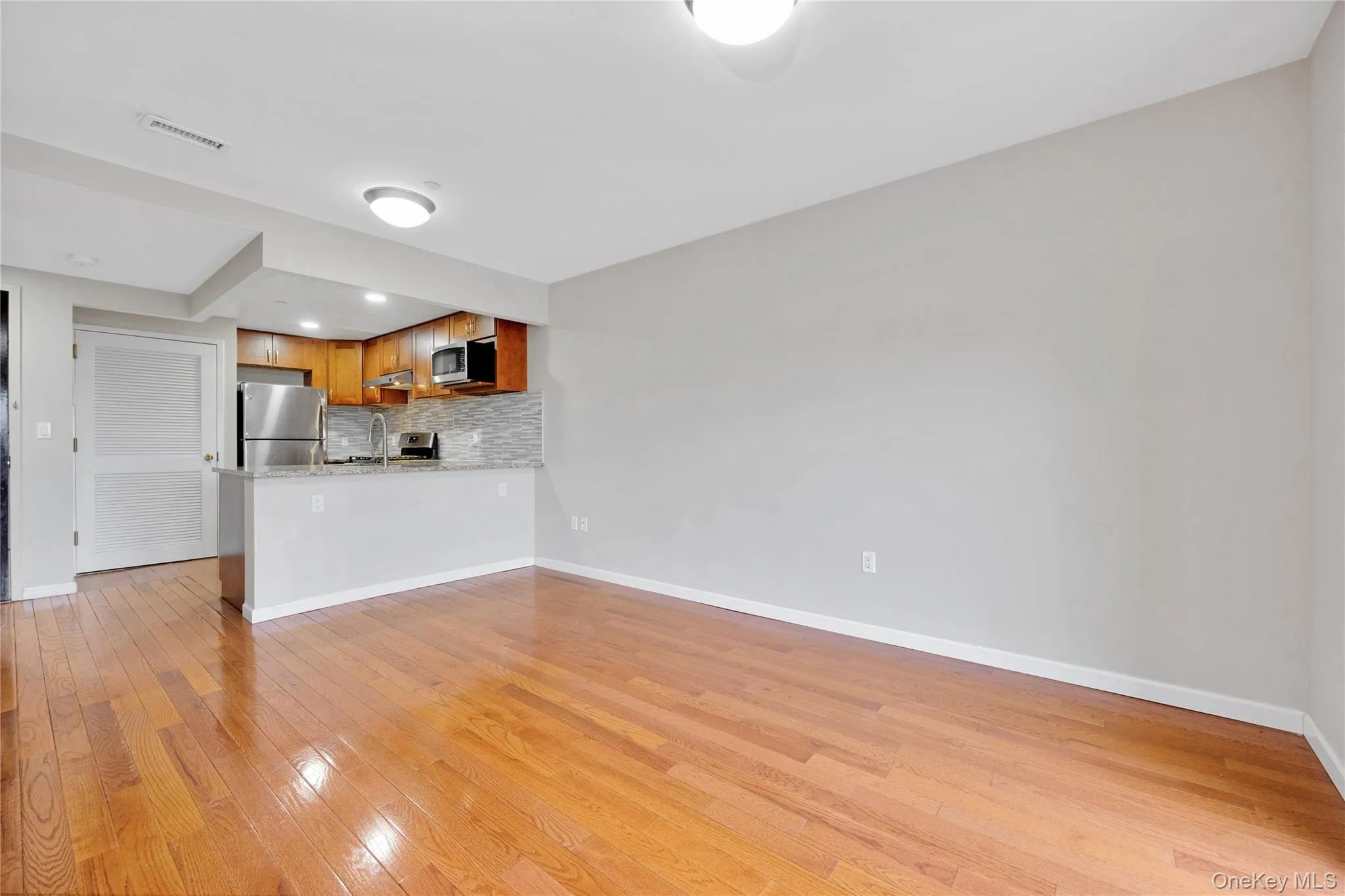Unfurnished living room featuring light wood-type flooring, baseboards, visible vents, and recessed lighting Unfurnished living room featuring light wood-type flooring, baseboards, visible vents, and recessed lighting