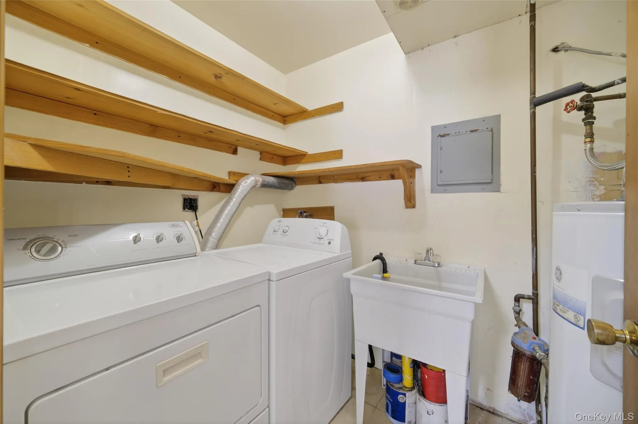 Laundry area featuring electric water heater and washer and clothes dryer Laundry area featuring electric water heater and washer and clothes dryer