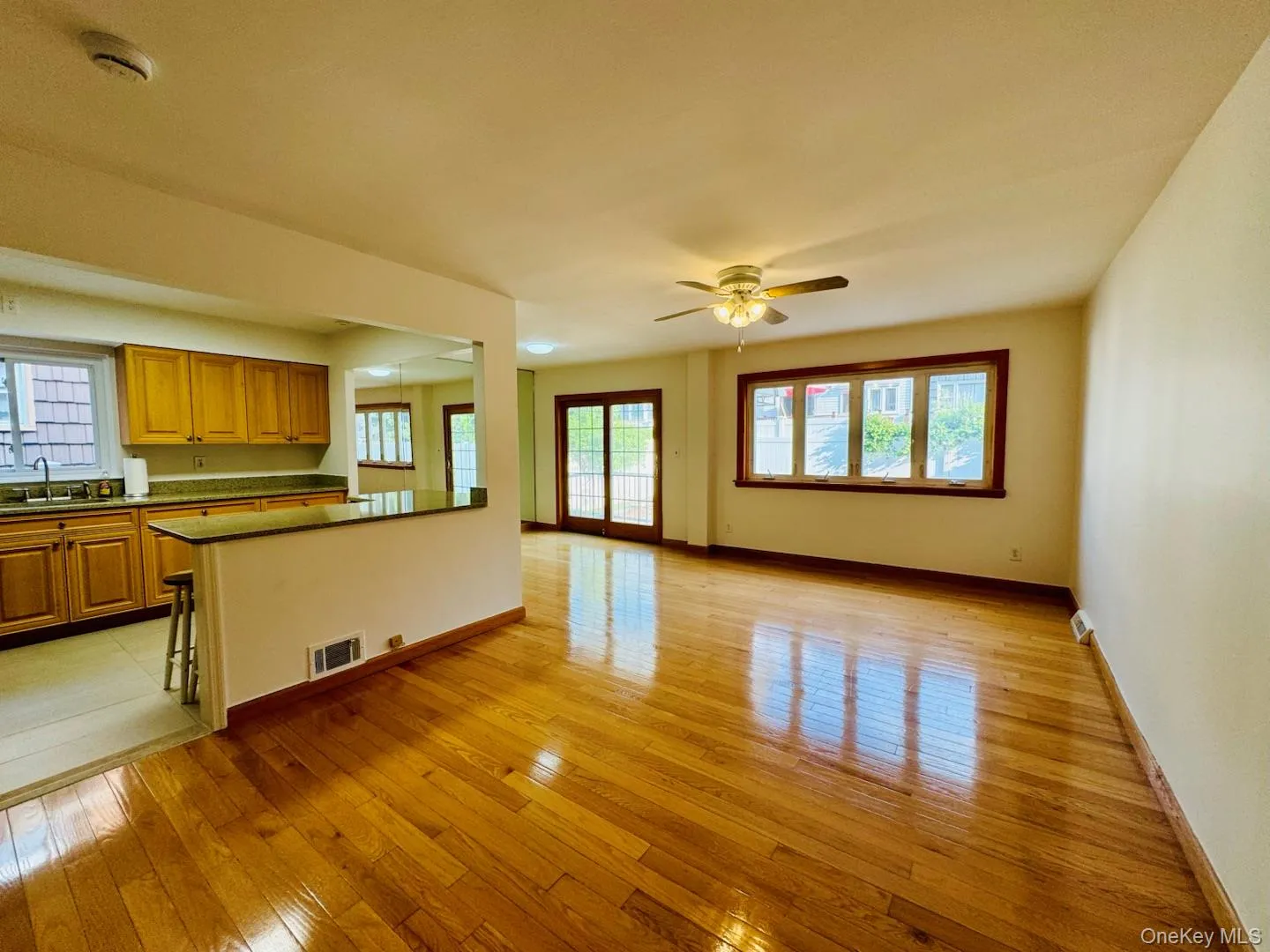 Unfurnished living room with light wood-style flooring, healthy amount of natural light, and a ceiling fan Unfurnished living room with light wood-style flooring, healthy amount of natural light, and a ceiling fan