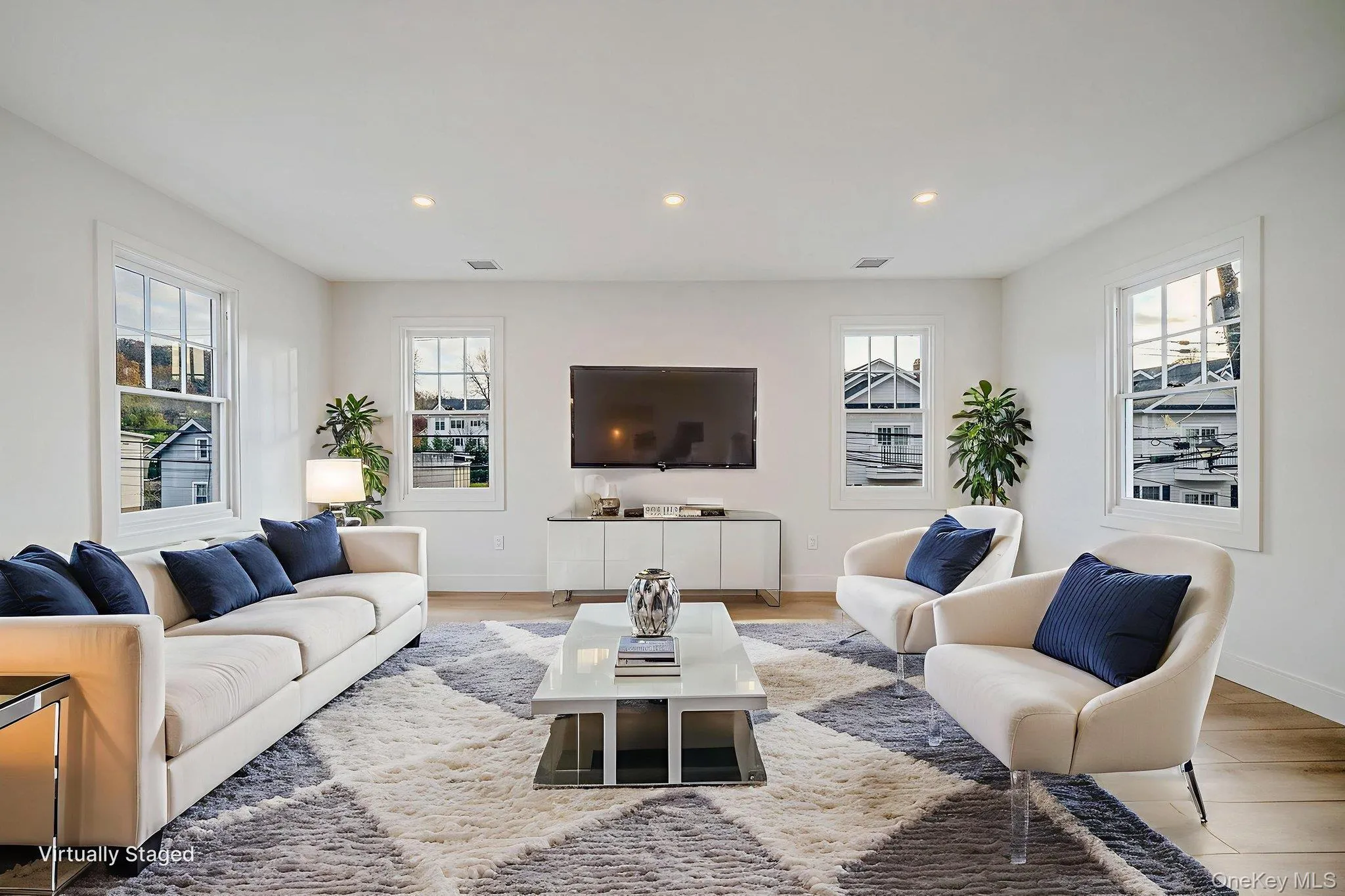 Living room featuring recessed lighting, plenty of natural light, and wood finished floors Living room featuring recessed lighting, plenty of natural light, and wood finished floors