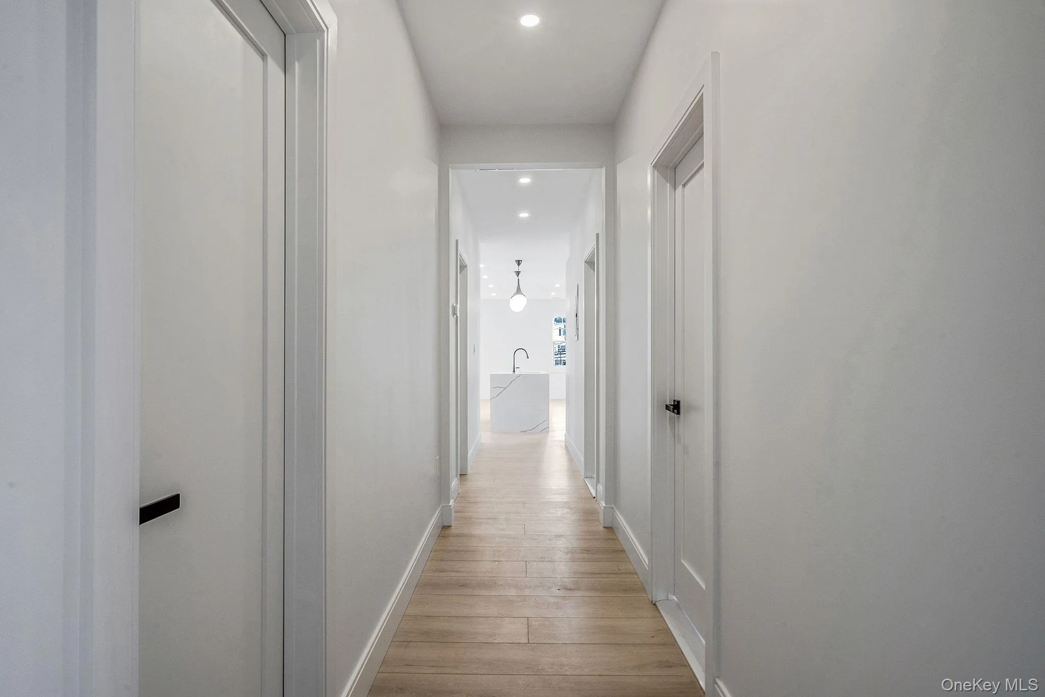 Corridor featuring light wood-style floors and recessed lighting Corridor featuring light wood-style floors and recessed lighting