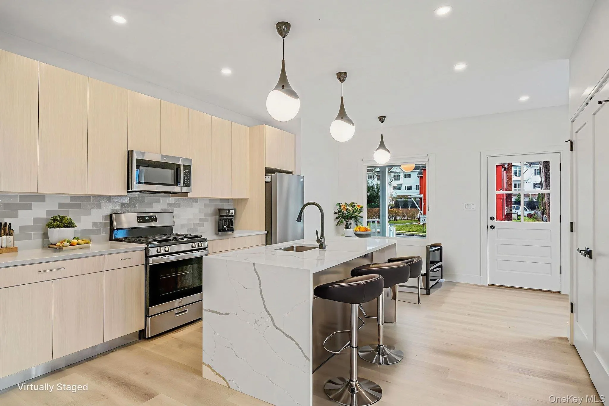 Kitchen featuring modern cabinets, light brown cabinetry, appliances with stainless steel finishes, decorative light fixtures, and recessed lighting Kitchen featuring modern cabinets, light brown cabinetry, appliances with stainless steel finishes, decorative light fixtures, and recessed lighting