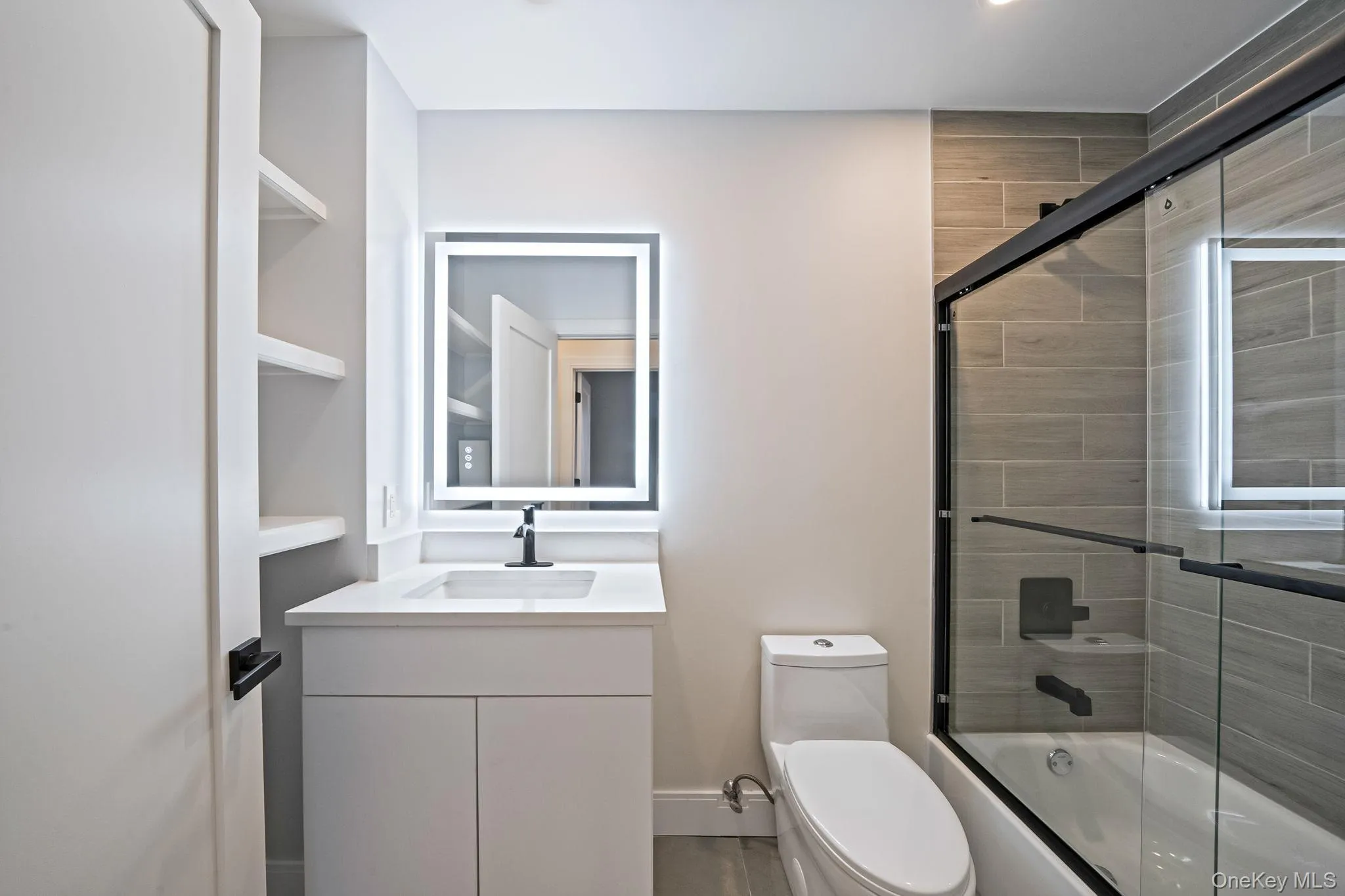 Full bathroom featuring vanity and enclosed tub / shower combo Full bathroom featuring vanity and enclosed tub / shower combo