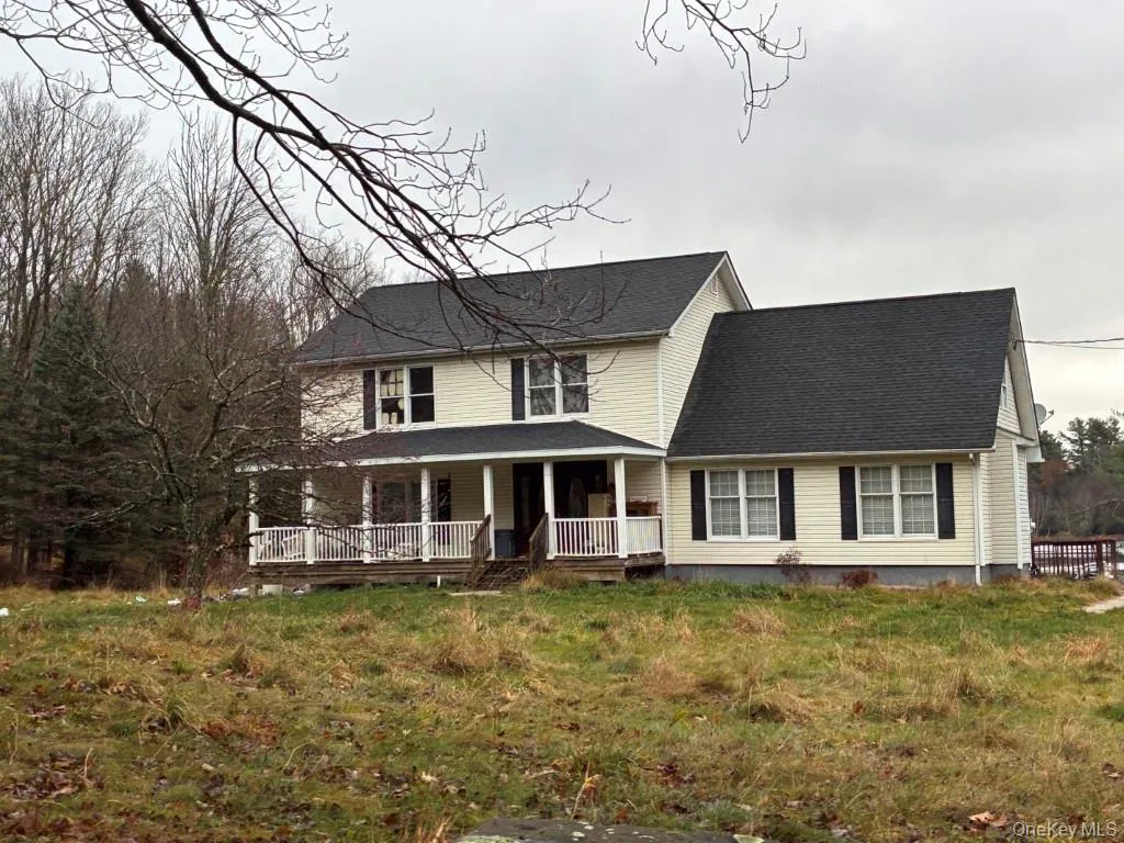 View of front facade with a porch, roof with shingles, and a front yard View of front facade with a porch, roof with shingles, and a front yard