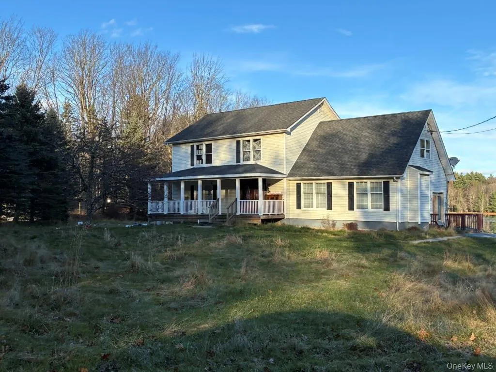 View of front facade featuring a porch, a shingled roof, and a front lawn View of front facade featuring a porch, a shingled roof, and a front lawn