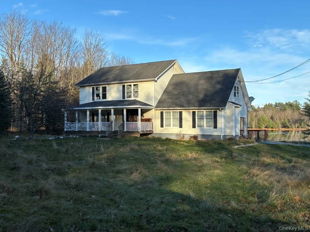 View of front of home with covered porch, a front yard, and roof with shingles View of front of home with covered porch, a front yard, and roof with shingles
