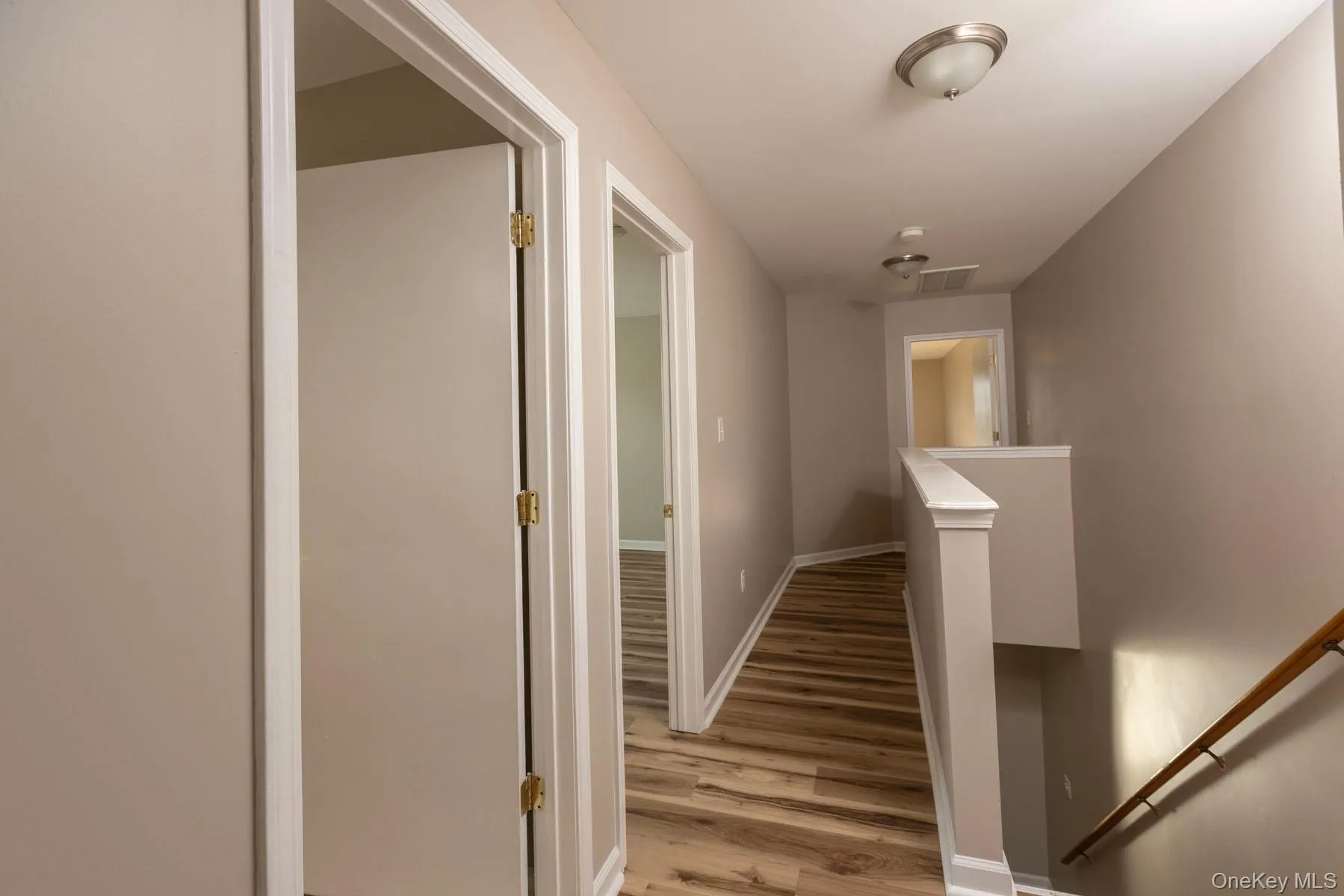 Hallway with an upstairs landing and light wood-style flooring Hallway with an upstairs landing and light wood-style flooring