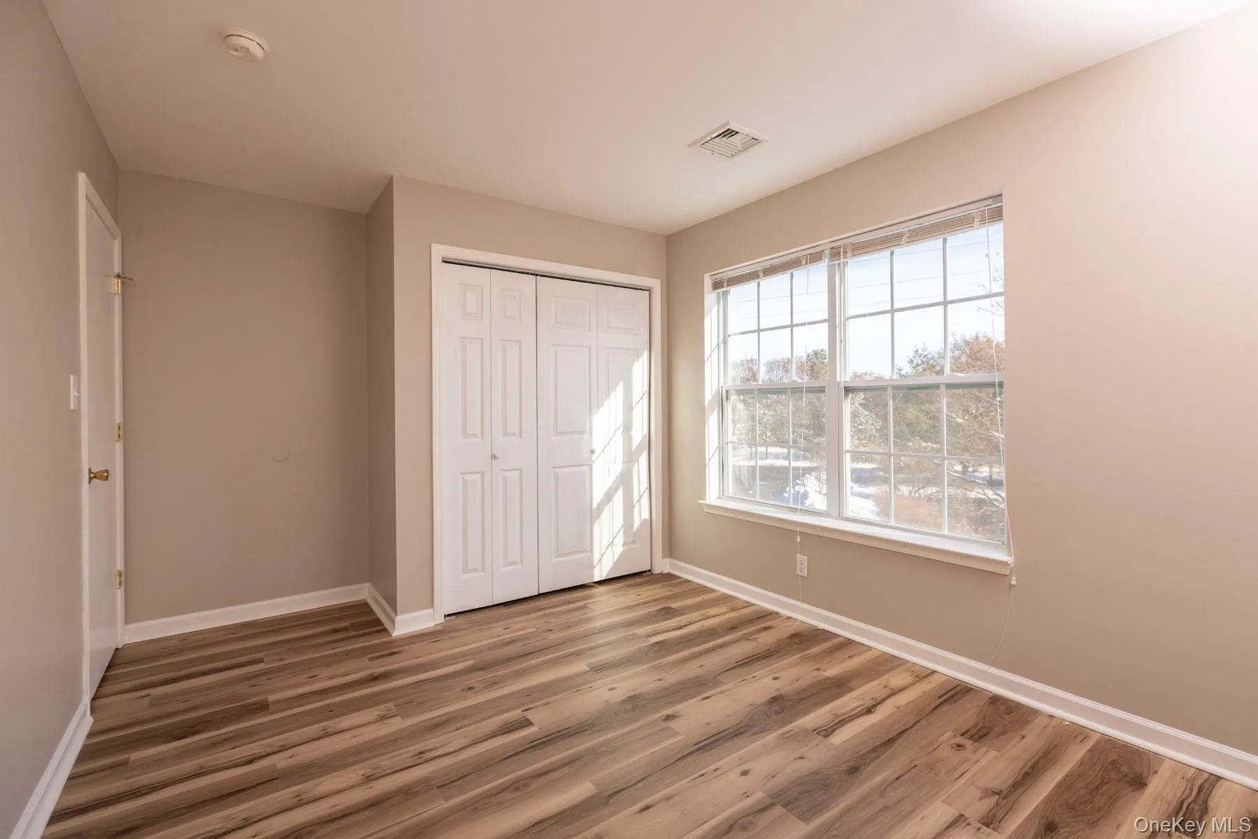 Unfurnished bedroom with wood finished floors and a closet Unfurnished bedroom with wood finished floors and a closet