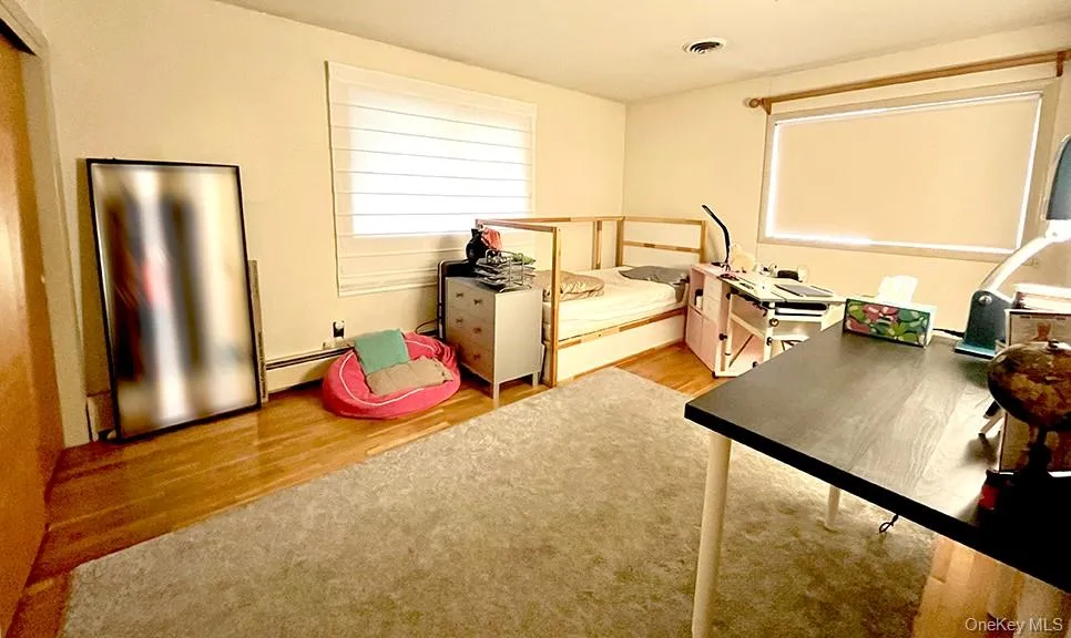 Bedroom featuring light wood-style floors and baseboard heating Bedroom featuring light wood-style floors and baseboard heating