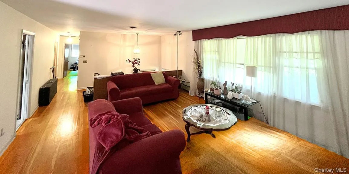 Living room with plenty of natural light and wood finished floors Living room with plenty of natural light and wood finished floors