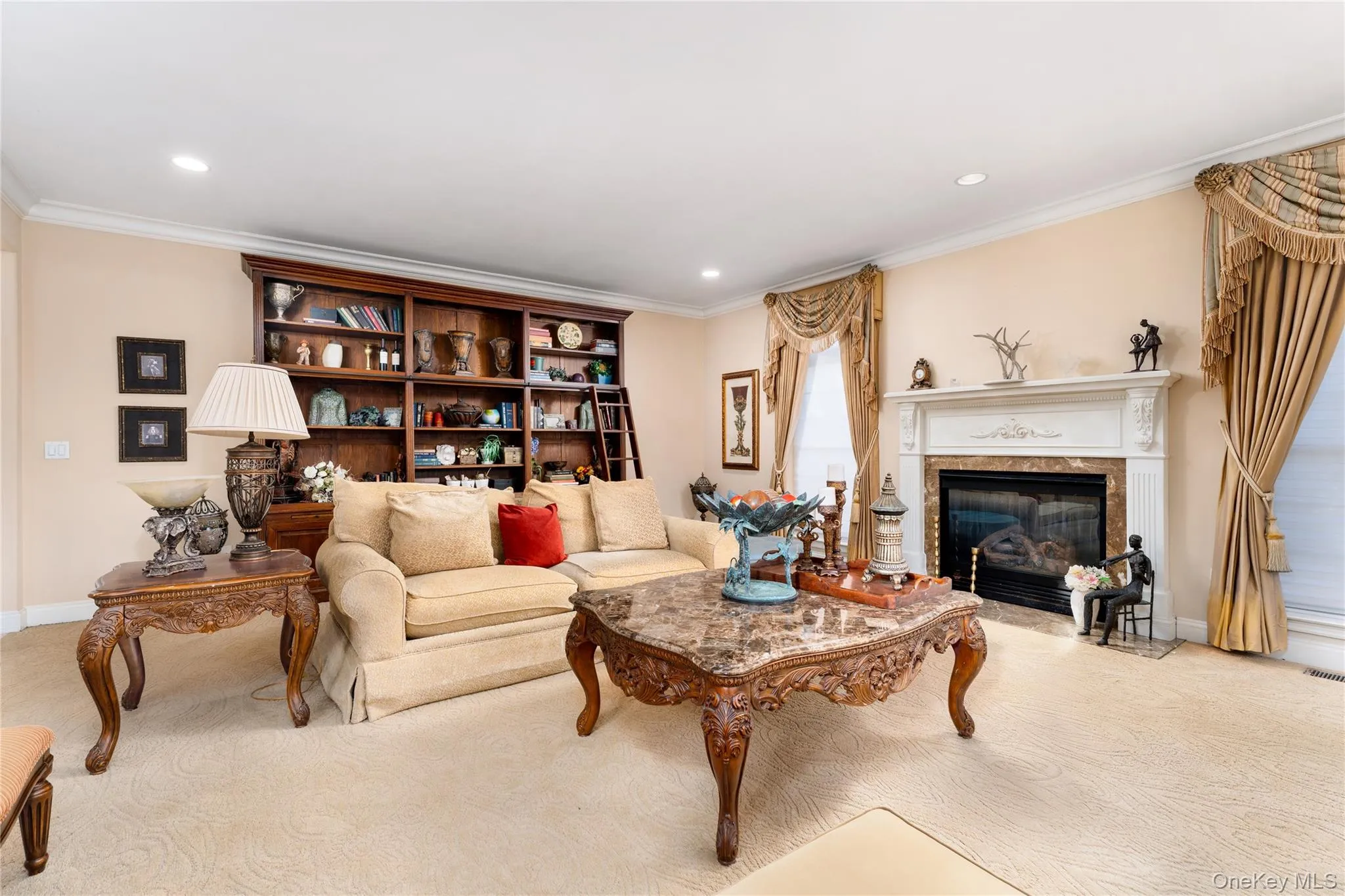 Living area featuring light carpet, a fireplace, ornamental molding, and recessed lighting Living area featuring light carpet, a fireplace, ornamental molding, and recessed lighting