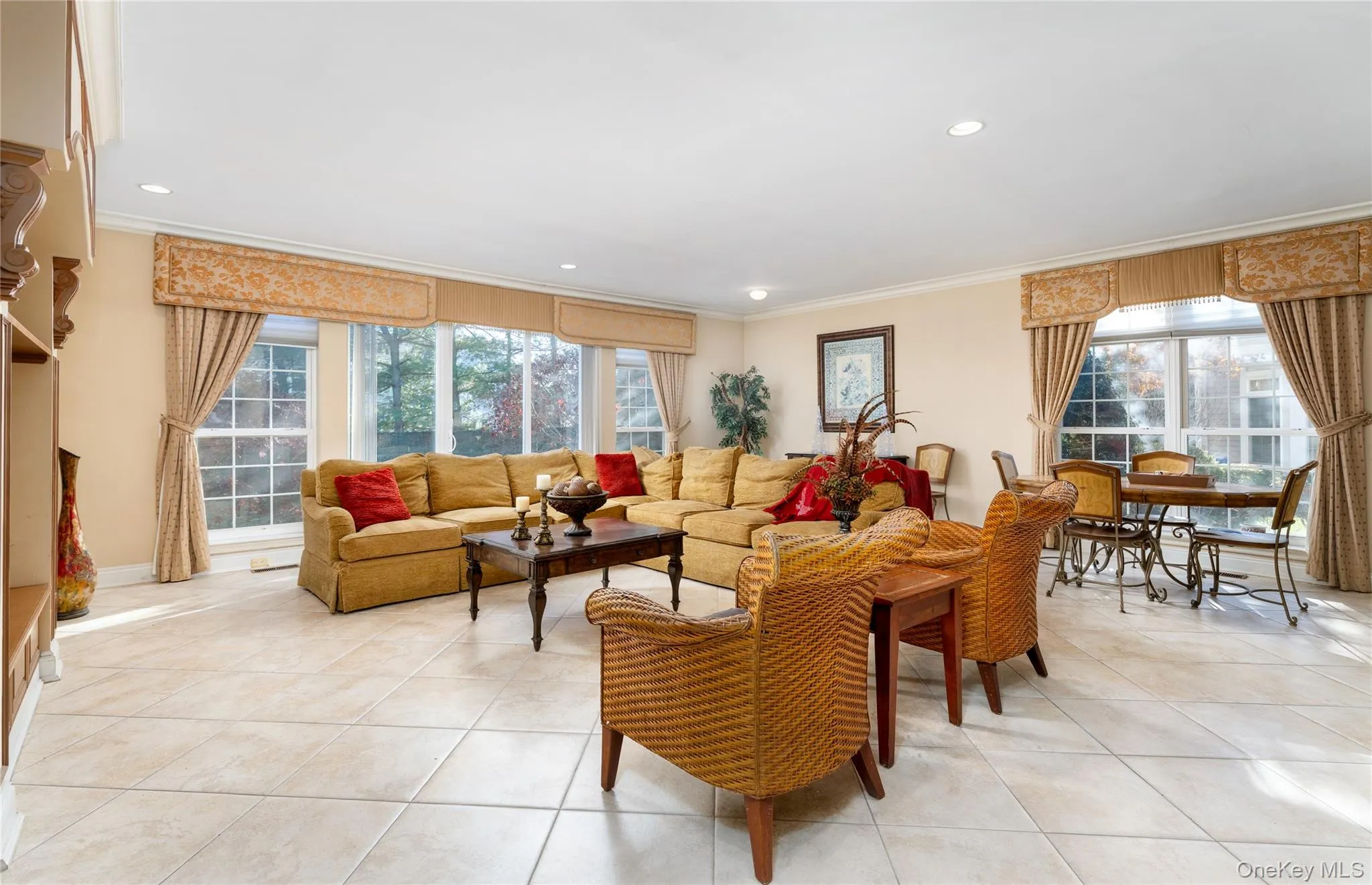 Living room with light tile patterned floors, recessed lighting, and crown molding Living room with light tile patterned floors, recessed lighting, and crown molding