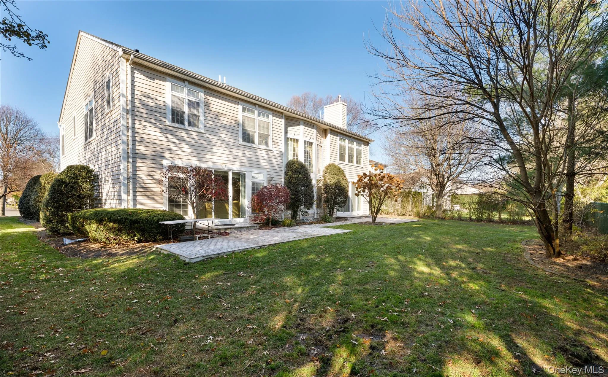 Rear view of property with a chimney, a patio, and a lawn Rear view of property with a chimney, a patio, and a lawn