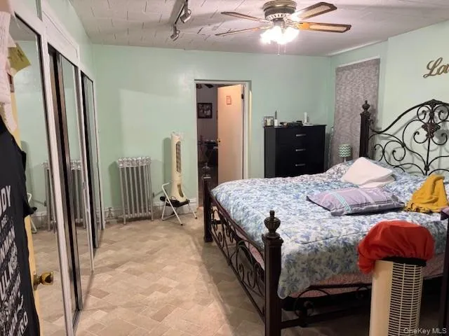 Bedroom featuring ceiling fan, rail lighting, and a closet Bedroom featuring ceiling fan, rail lighting, and a closet
