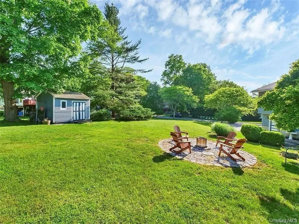 View of yard featuring a shed and a fire pit View of yard featuring a shed and a fire pit