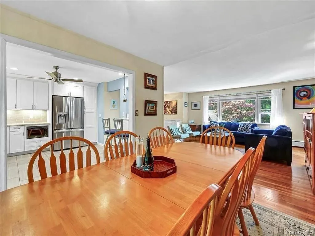 Dining space with a baseboard heating unit, ceiling fan, and light hardwood / wood-style floors Dining space with a baseboard heating unit, ceiling fan, and light hardwood / wood-style floors