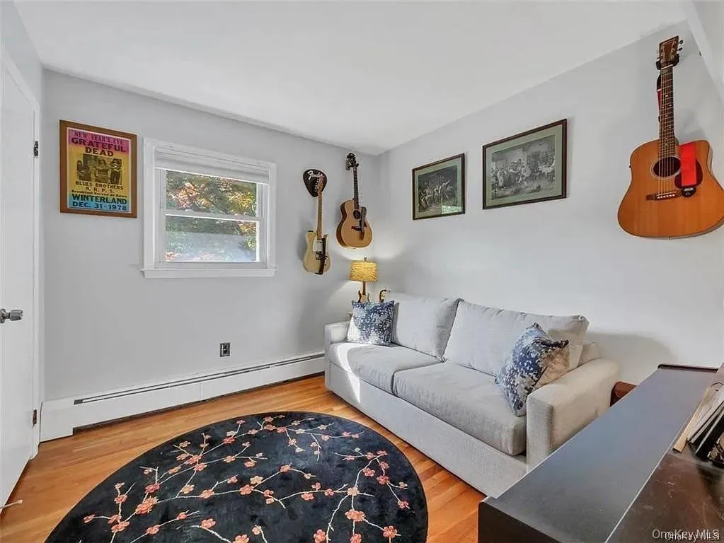 Living room with a baseboard heating unit and wood-type flooring Living room with a baseboard heating unit and wood-type flooring