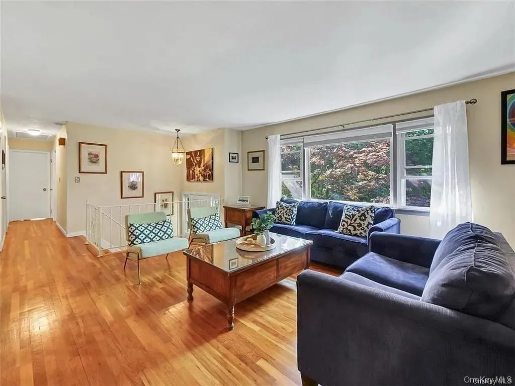 Living room with light hardwood / wood-style flooring and a notable chandelier Living room with light hardwood / wood-style flooring and a notable chandelier