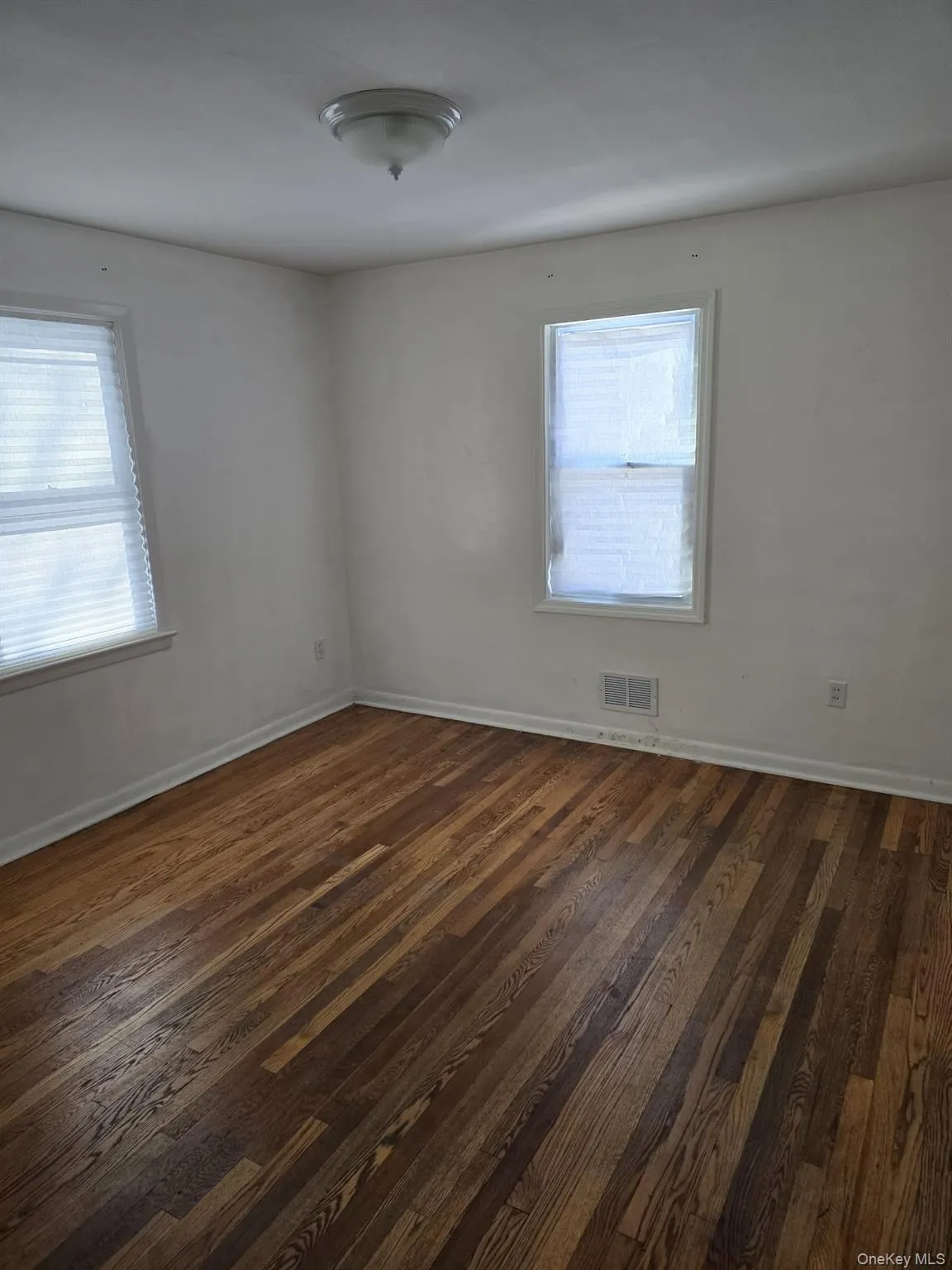 Spare room with dark wood finished floors and plenty of natural light Spare room with dark wood finished floors and plenty of natural light