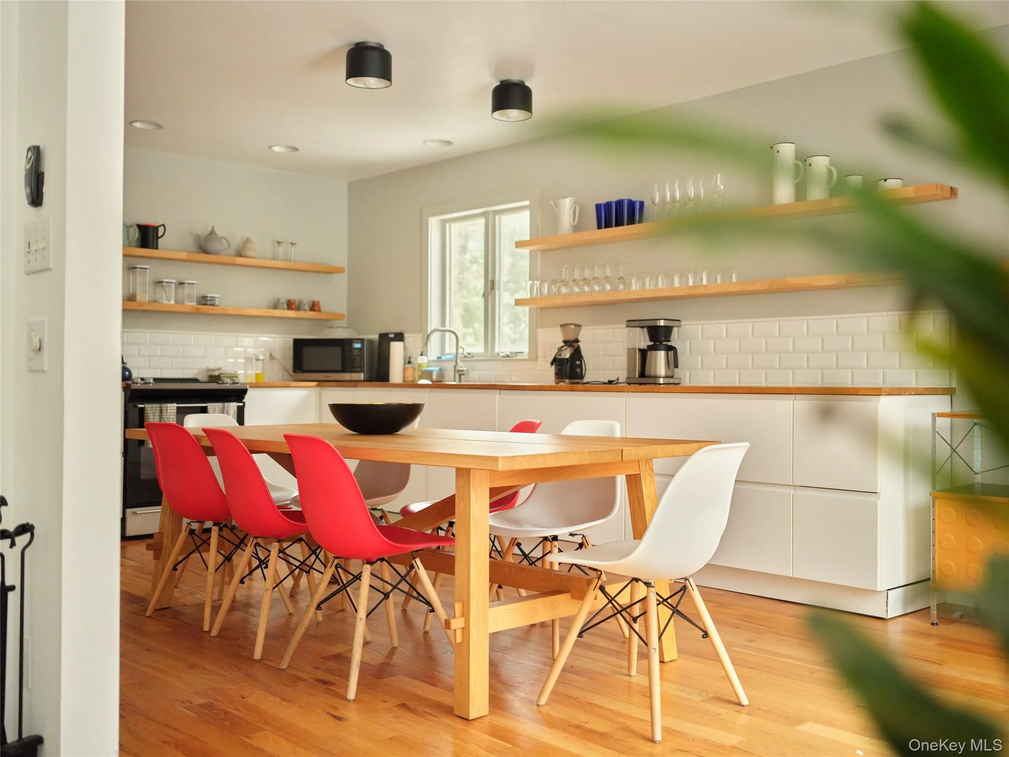 Kitchen with open shelves, white cabinets, tasteful backsplash, and light wood finished floors Kitchen with open shelves, white cabinets, tasteful backsplash, and light wood finished floors