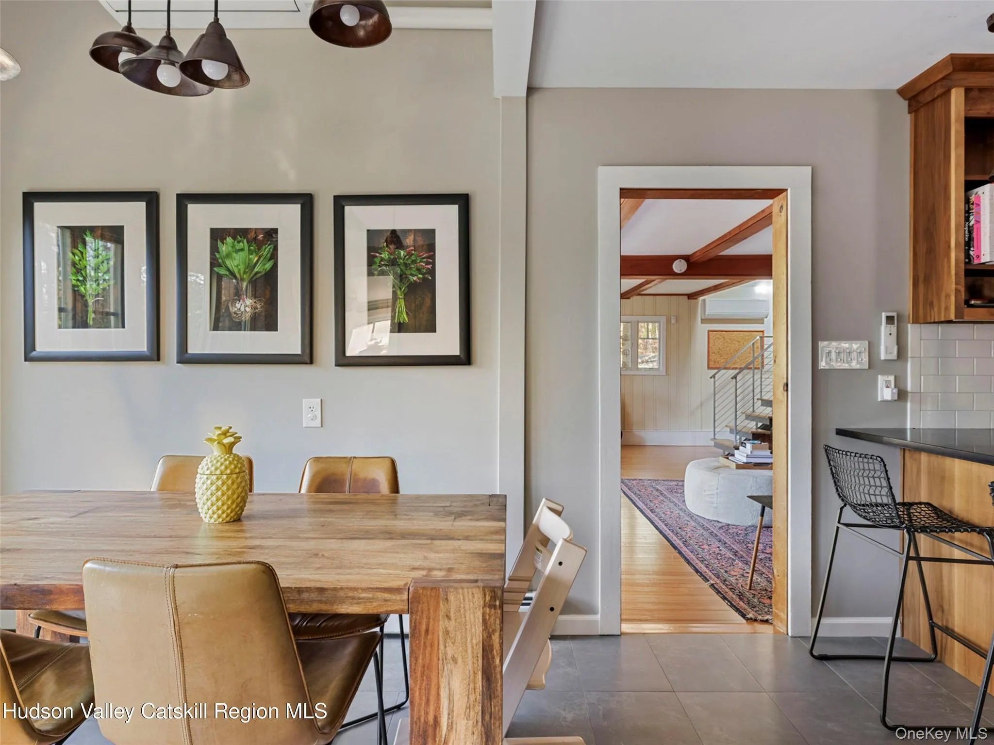Dining space with beamed ceiling and dark tile patterned floors Dining space with beamed ceiling and dark tile patterned floors