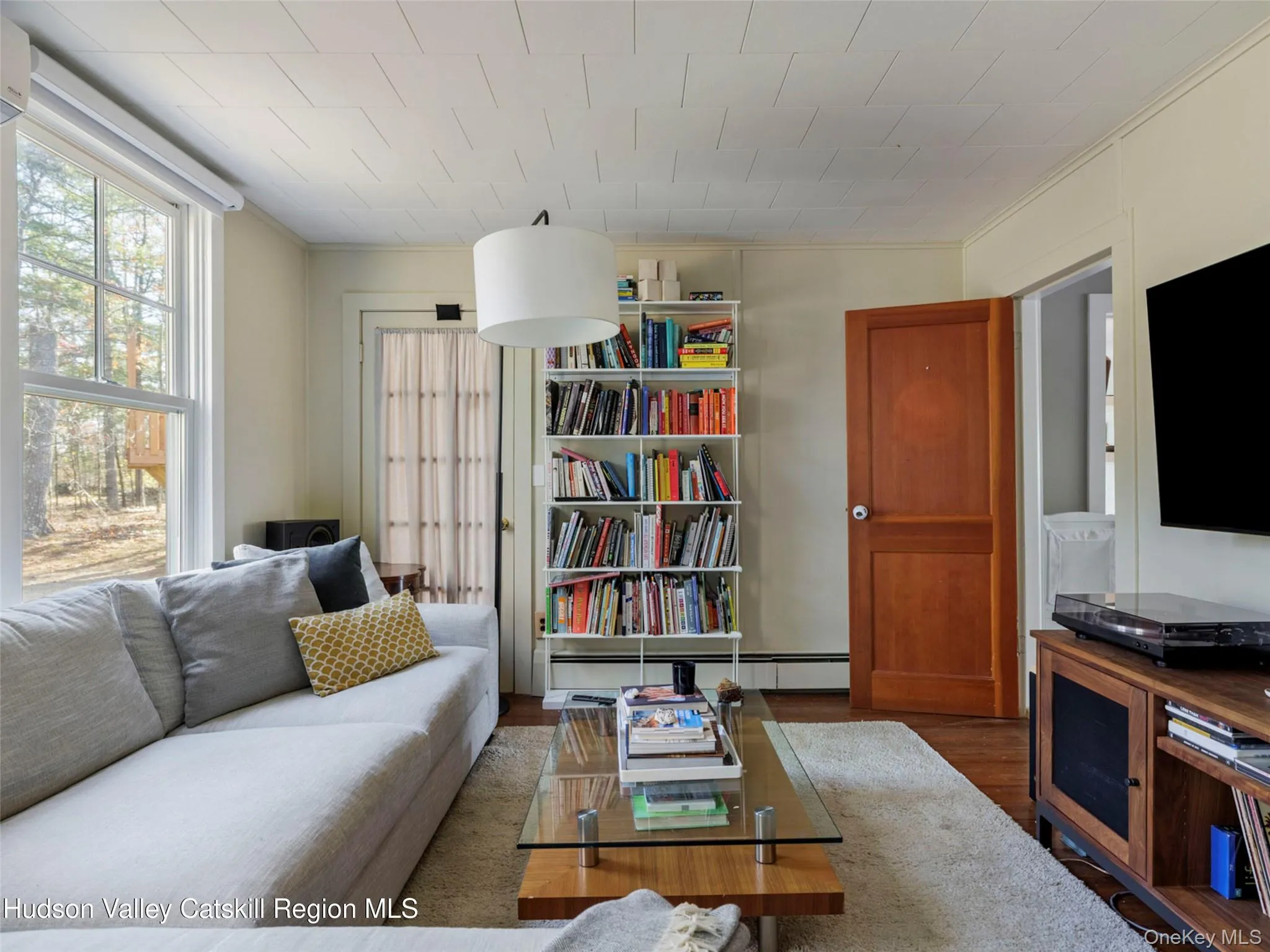 Living room with wood finished floors and a baseboard radiator Living room with wood finished floors and a baseboard radiator