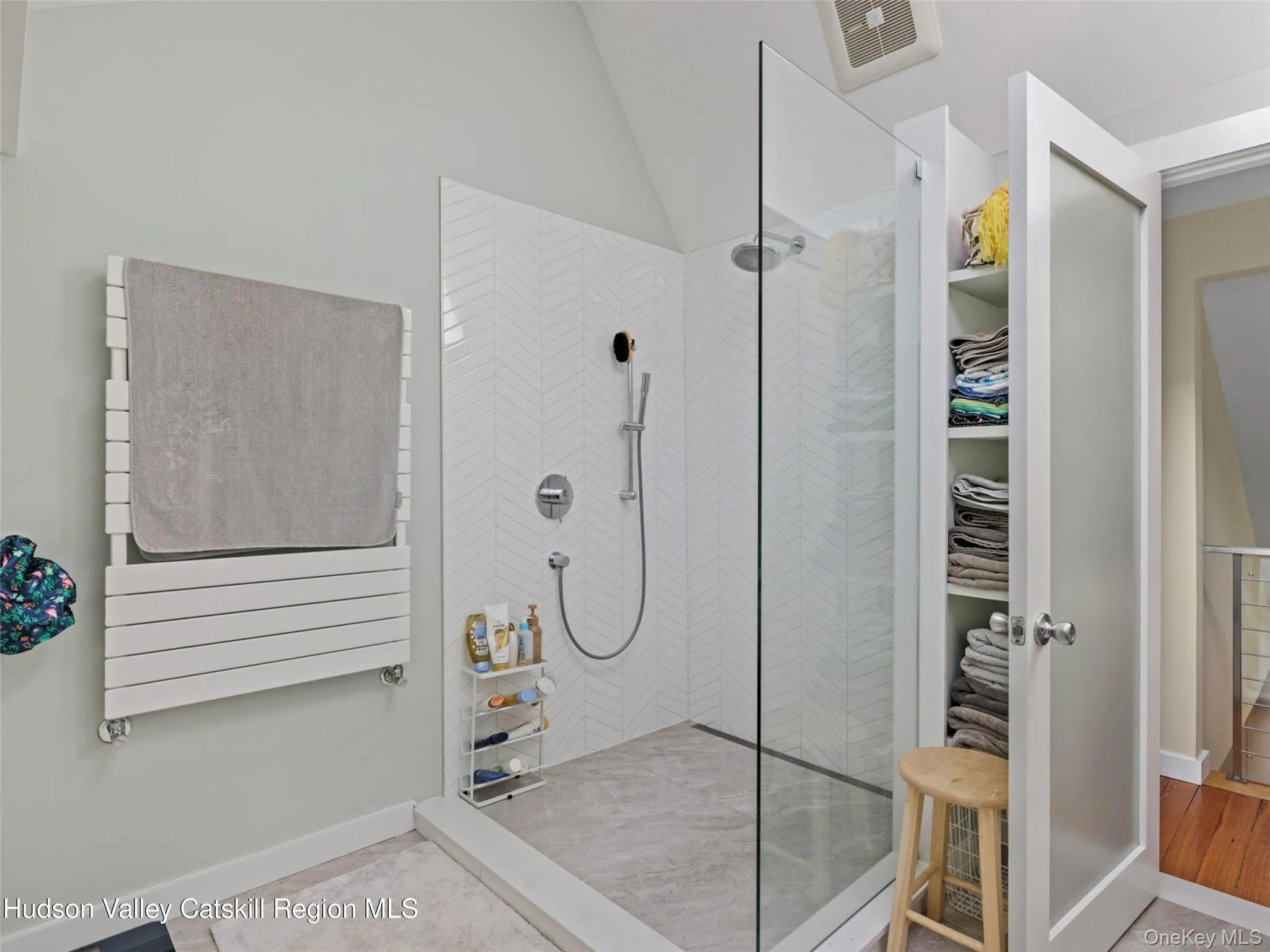 Bathroom featuring a walk in shower, a walk in closet, and lofted ceiling Bathroom featuring a walk in shower, a walk in closet, and lofted ceiling