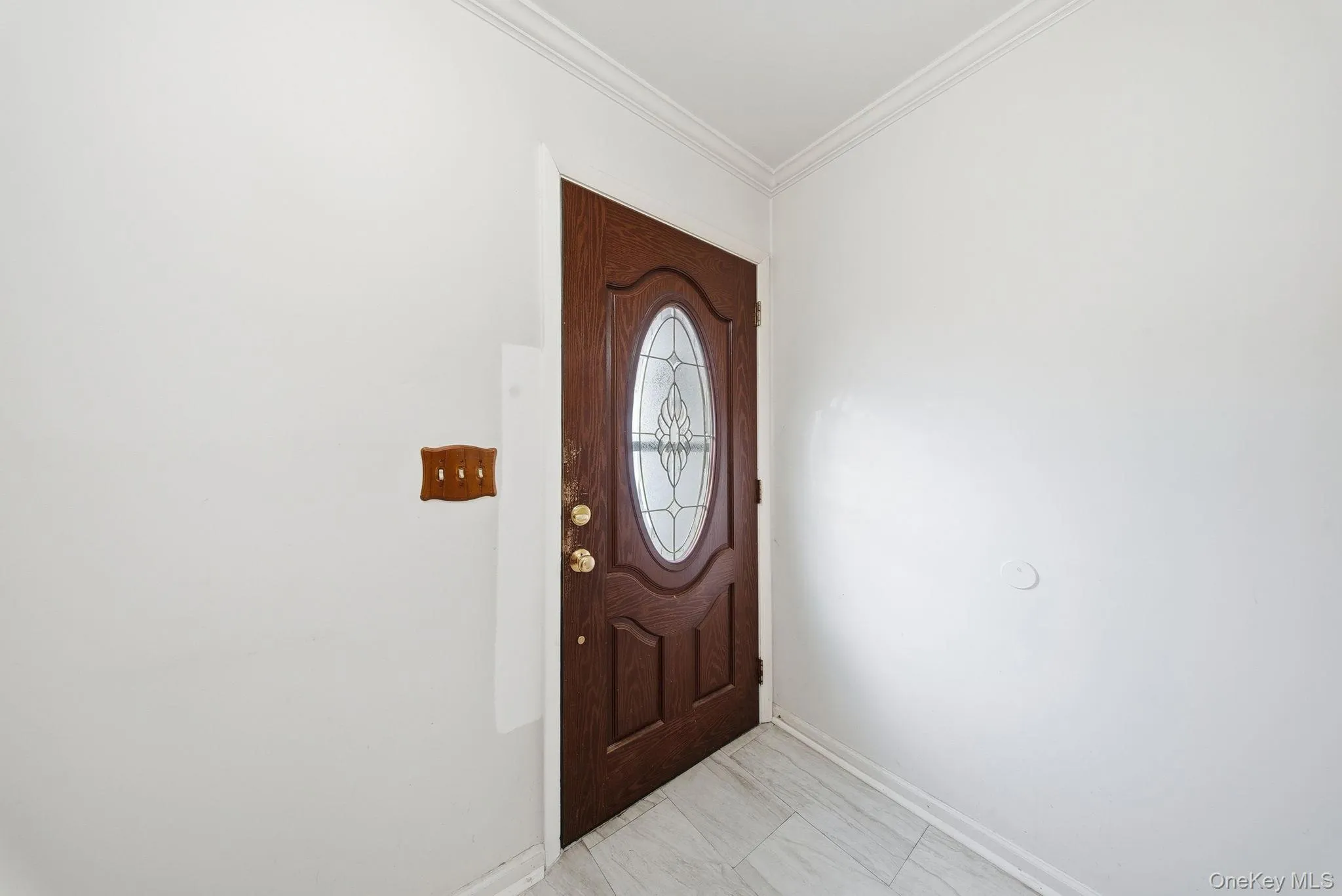 Entryway featuring baseboards and ornamental molding Entryway featuring baseboards and ornamental molding