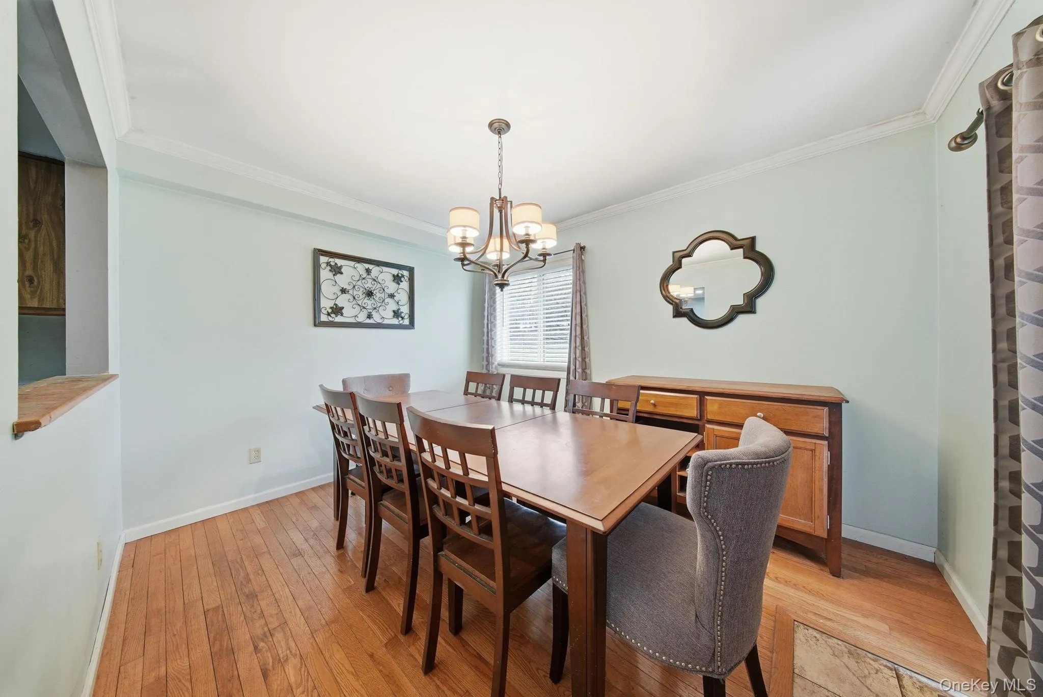 Dining space with light wood-style floors, a chandelier, and ornamental molding Dining space with light wood-style floors, a chandelier, and ornamental molding