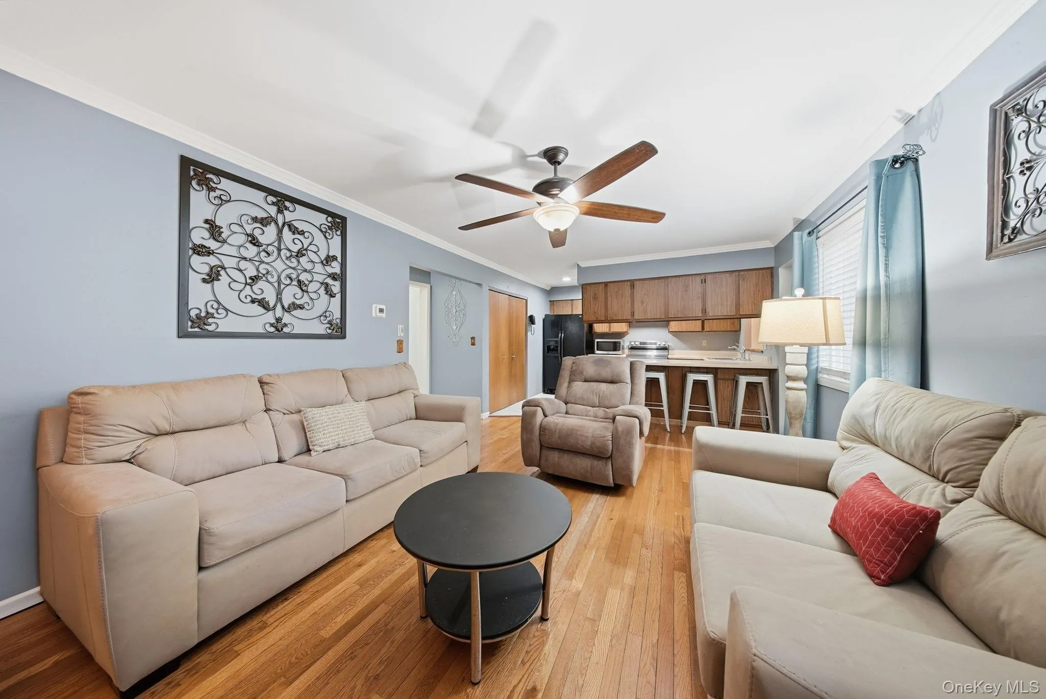 Living area featuring crown molding, light wood-style flooring, and ceiling fan Living area featuring crown molding, light wood-style flooring, and ceiling fan