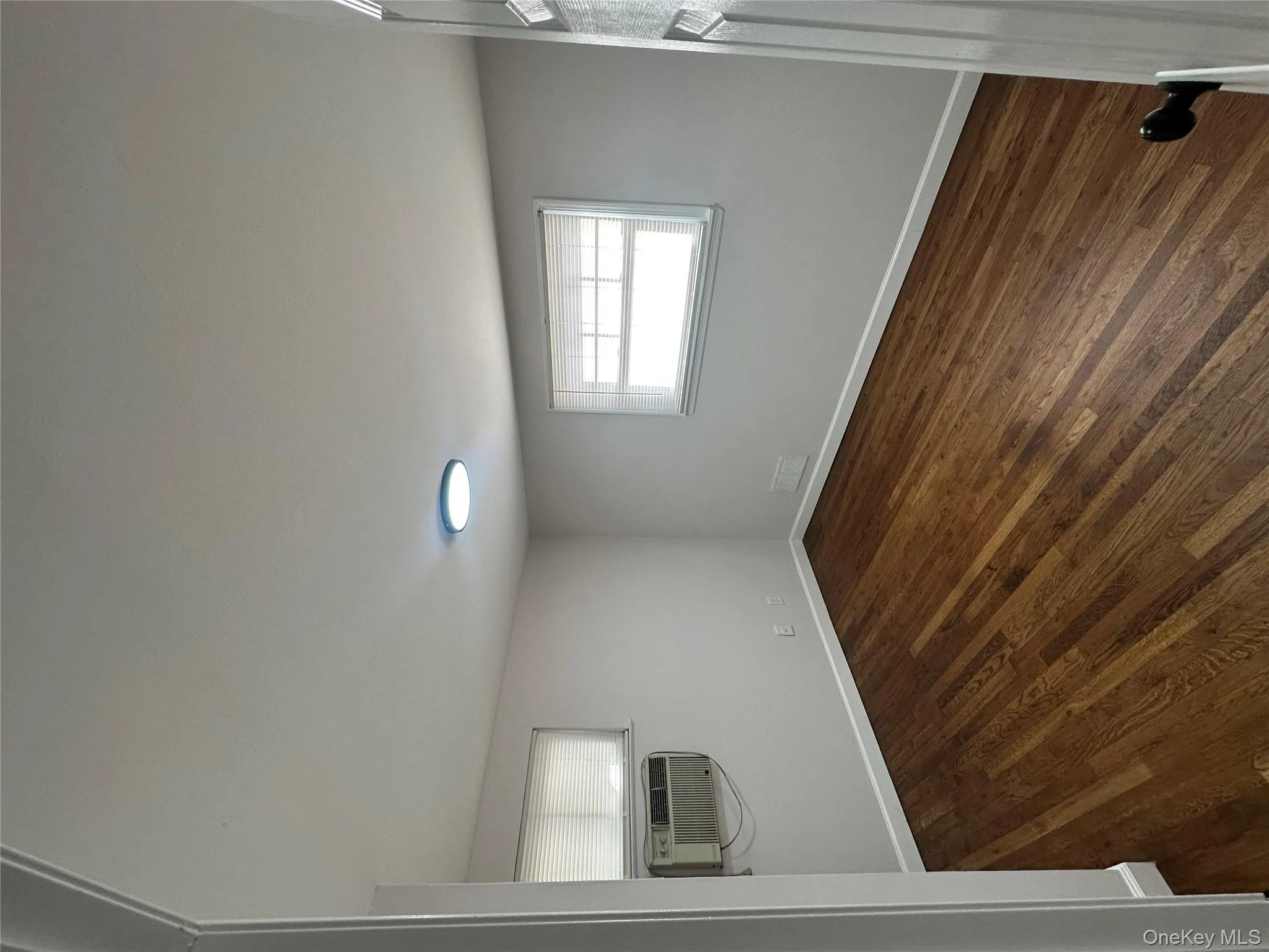 Spare room featuring dark wood-type flooring and baseboards Spare room featuring dark wood-type flooring and baseboards