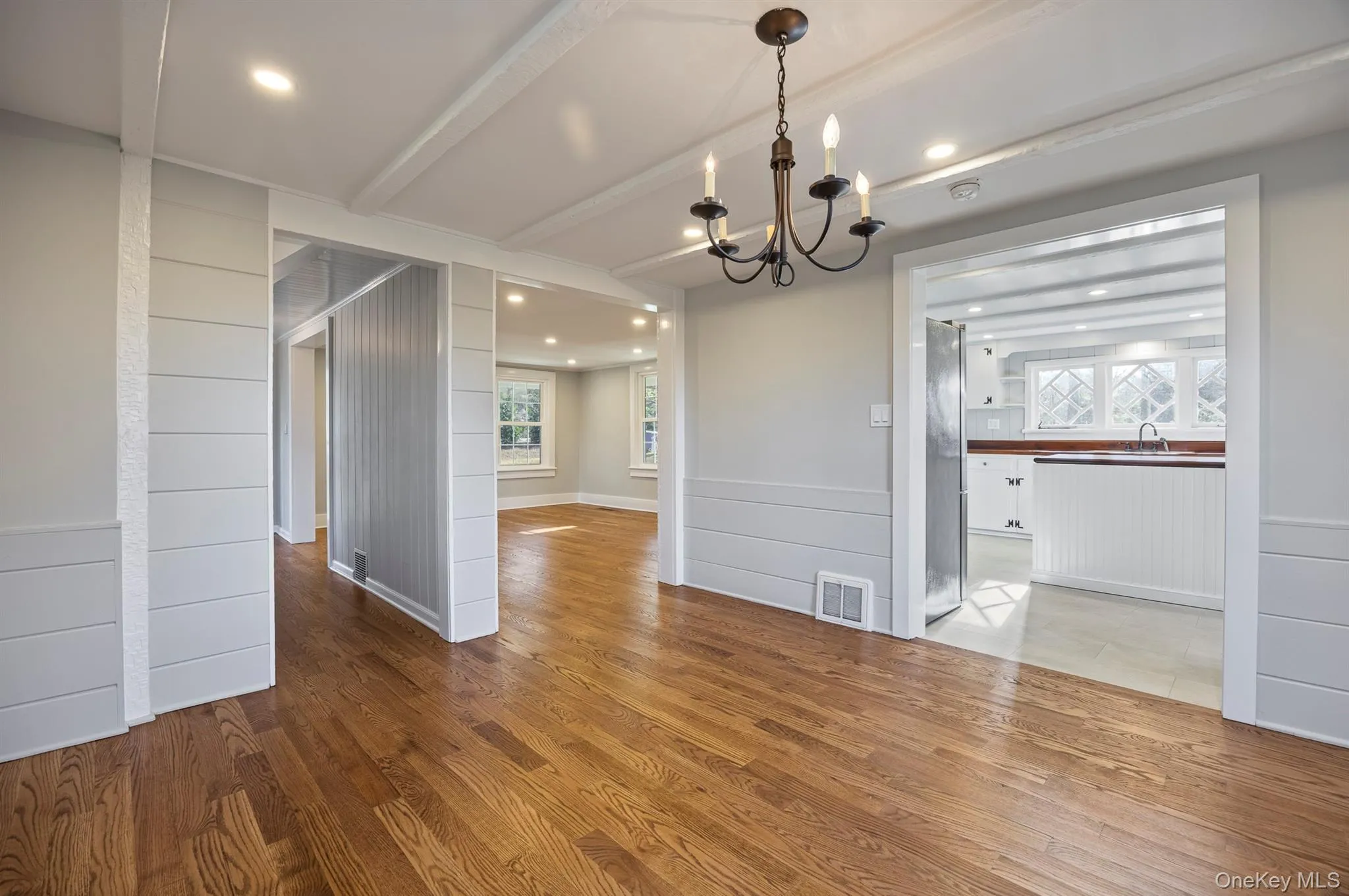 Dining area featuring wood finished floors, a chandelier, beamed ceiling, recessed lighting, and wood walls Dining area featuring wood finished floors, a chandelier, beamed ceiling, recessed lighting, and wood walls