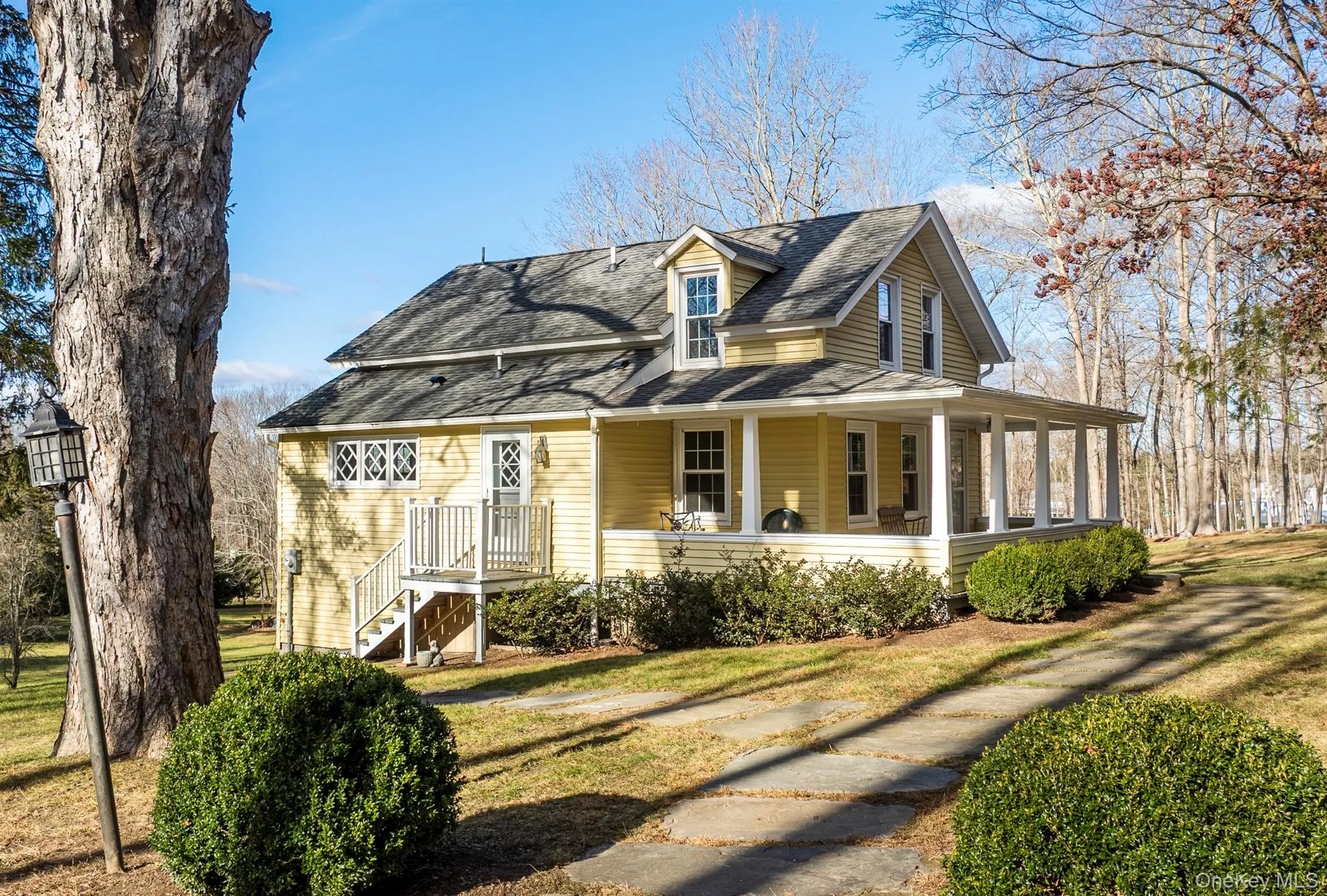 View of front of home featuring a porch, a shingled roof, and a front yard View of front of home featuring a porch, a shingled roof, and a front yard